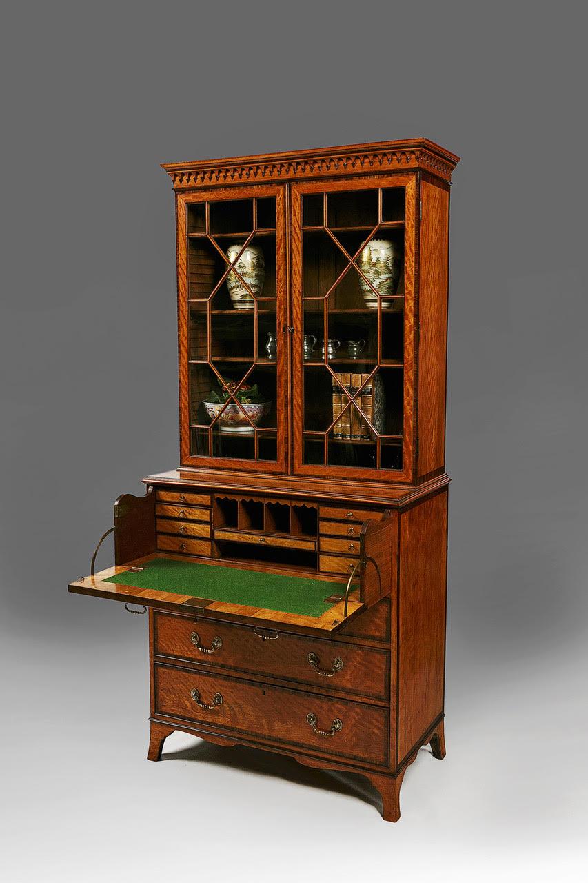 A very fine example of a George III Sheraton Period West Indian Satinwood Secretaire Bookcase of museum quality, firmly attributed to Gillows of Lancaster, England. Last quarter of the Eighteenth Century. 

The secretaire drawer front folds and