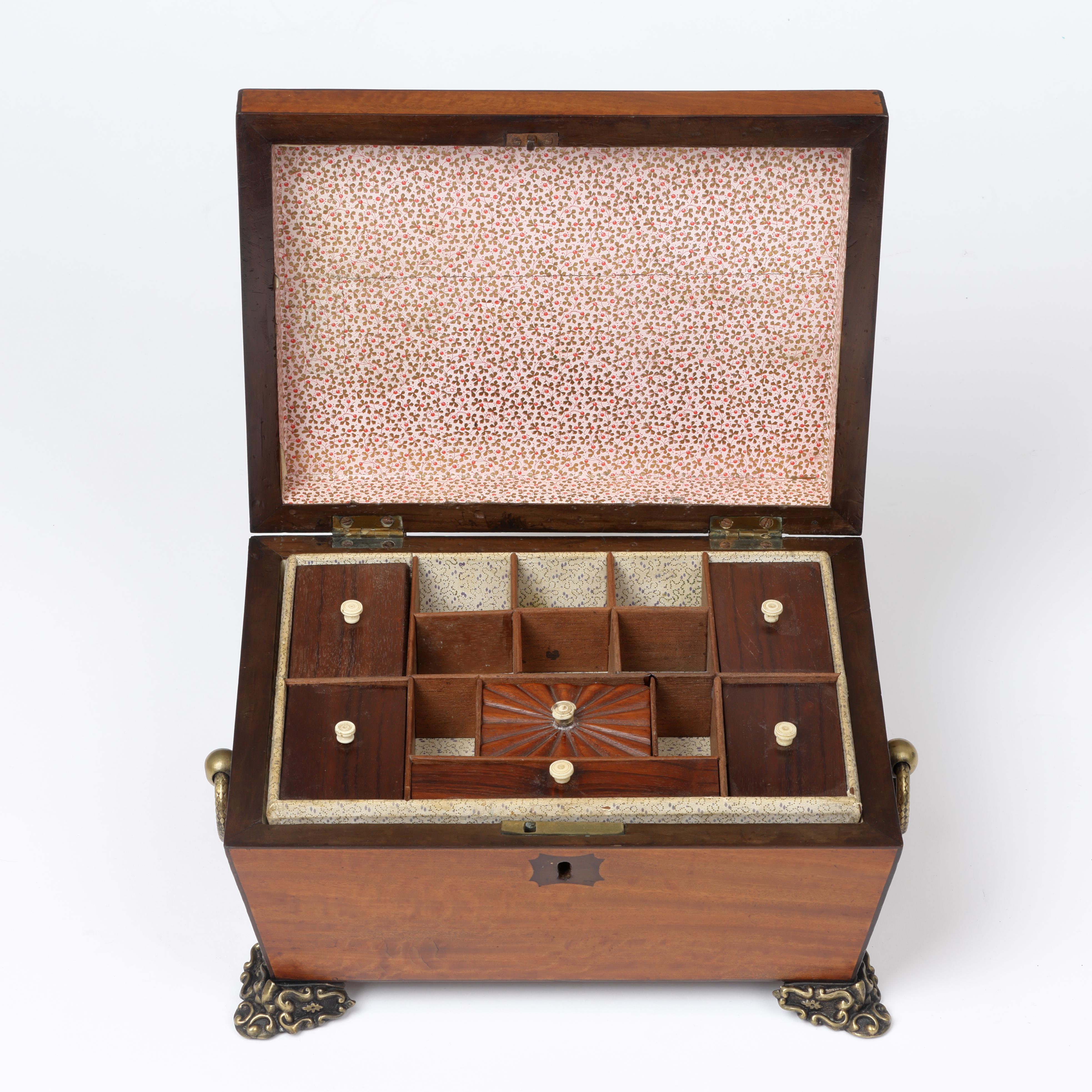 A fine early 19th century satinwood sarcophagus needlework or jewellery box with ornate brass ring handles and feet.