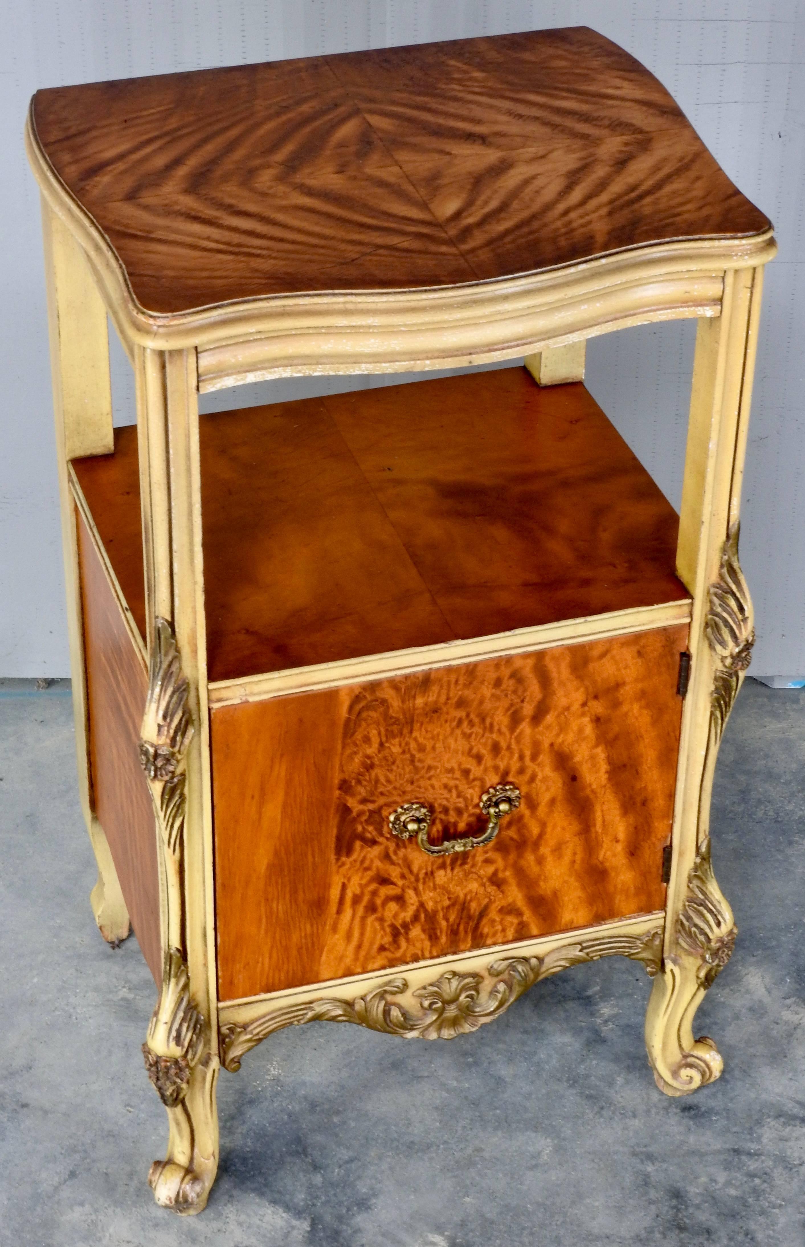 Elegant satinwood makes up a nightstand with ornate hand painted gold trim. Door opens with a cast bronze pull for storage. Two areas are available to display your treasures. The maker's tag is on the inside of the door. It was made by the J. B. Van