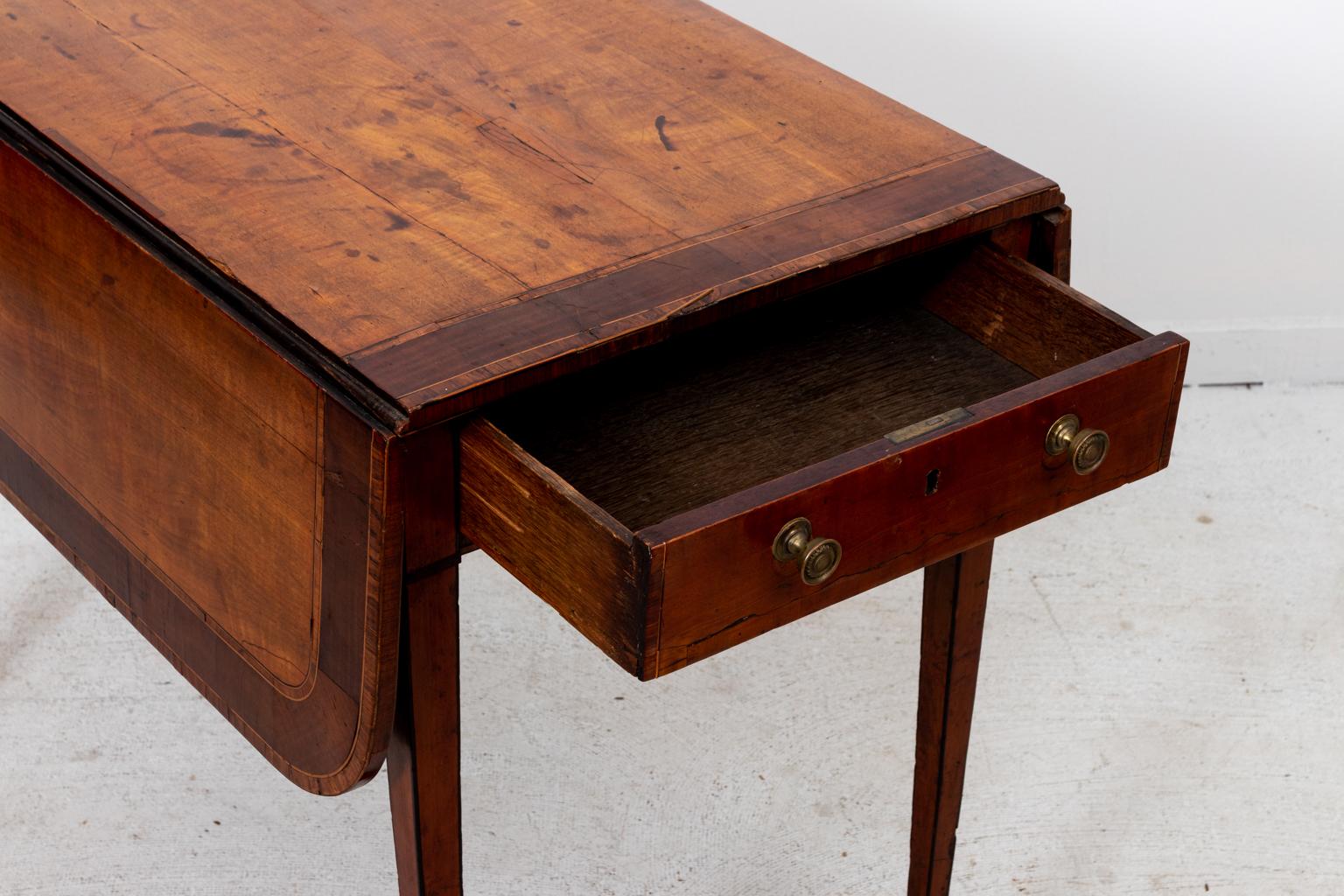 George III style blonde Satinwood drop-leaf pembroke table on castors with mahogany, rosewood veneer on oak, circa 1790s. The piece features an original key to the single, blind drawer and was previously owned by New York Opera singer Von Sickle.