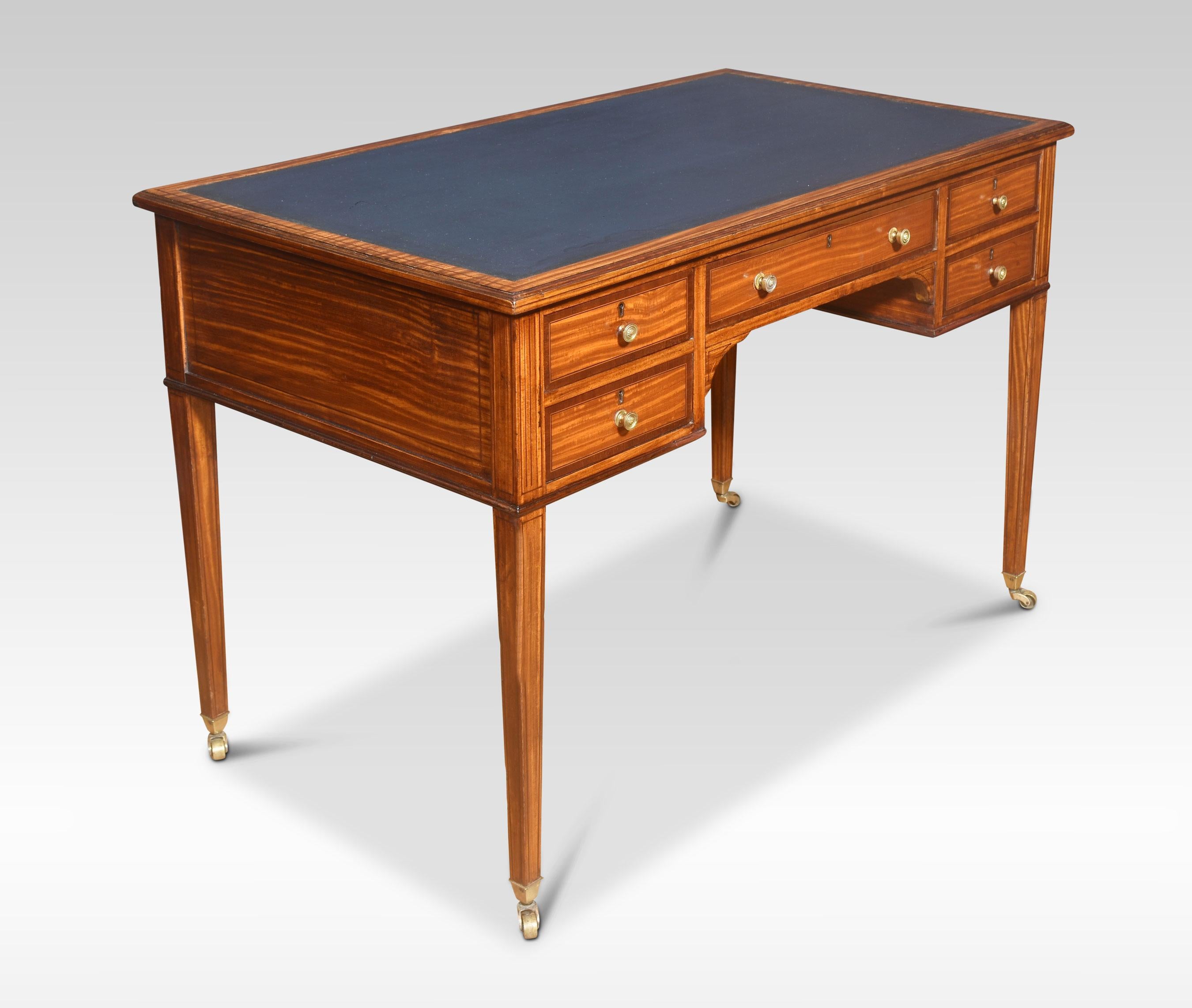 Satinwood writing table having a blue inset leather top enclosed by satinwood border. Above and arrangement of drawers with brass knob handles. All are raised up on four square supports terminating in brass casters.
Dimensions
Height 29 Inches
Width