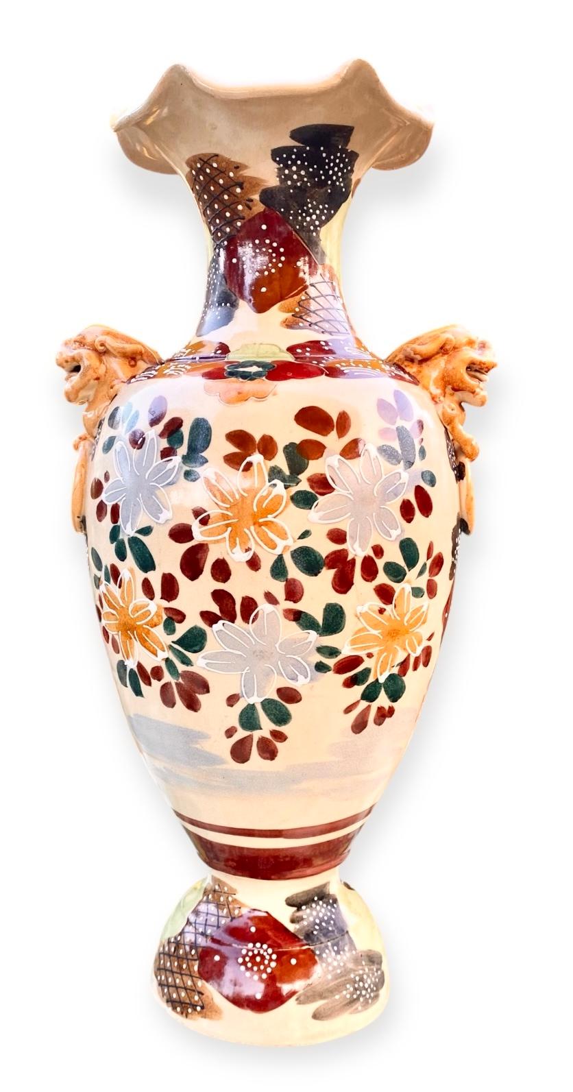 An early 20th century antique Japanese Taisho Period Satsuma vase, with hand painted moriage (raised paint) fighting Samurai warriors on one side and a floral scene on the reverse. The piece has stunning figural handles and is signed indistinctly on