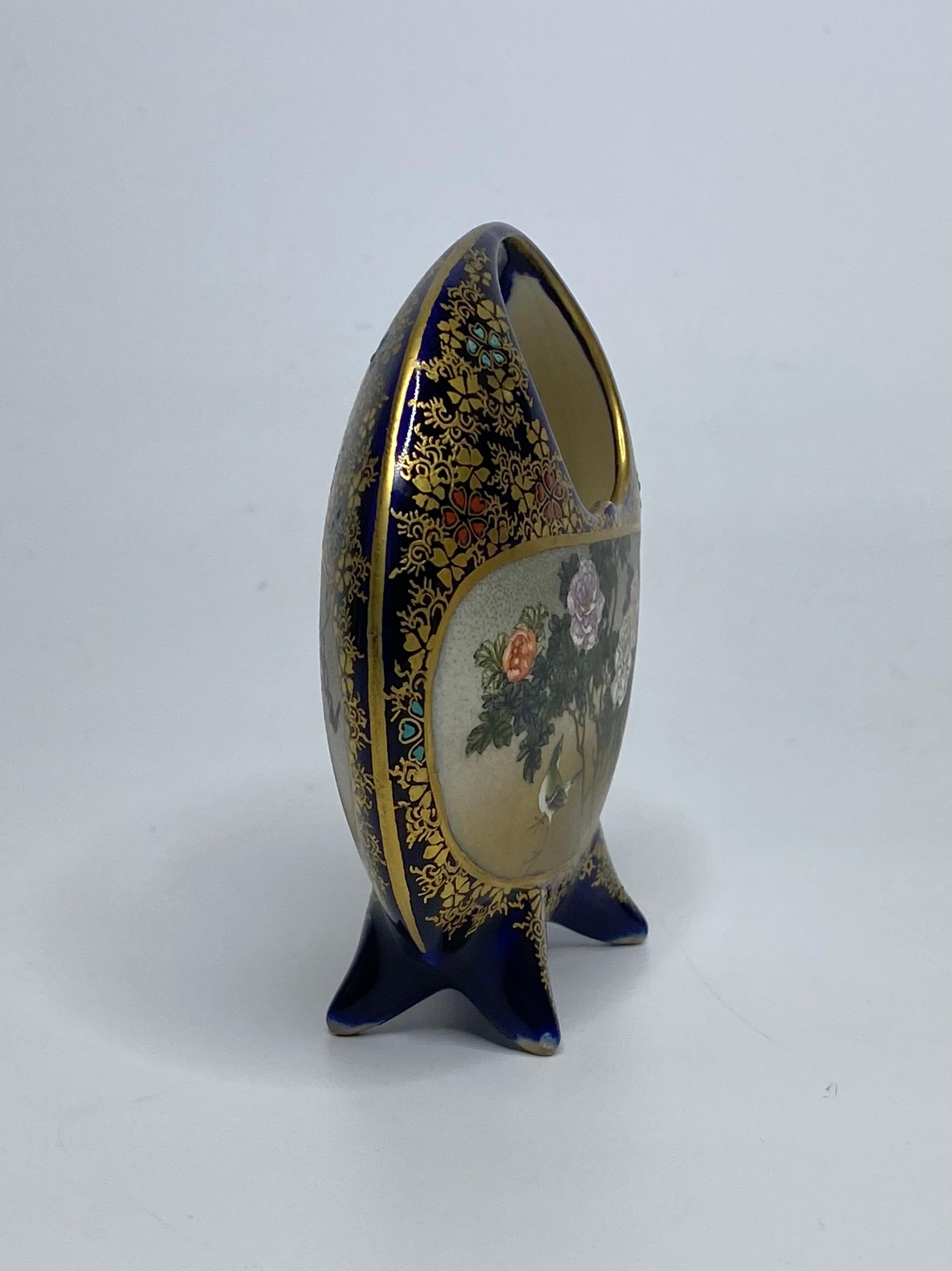 Satsuma pottery basket, Kinkozan, Meiji Period. The circular basket, hand painted with a panel of a bird, walking beneath flowering plants. The reverse with flowering wisteria.
All on an underglaze cobalt blue ground, with a dense covering of gilt