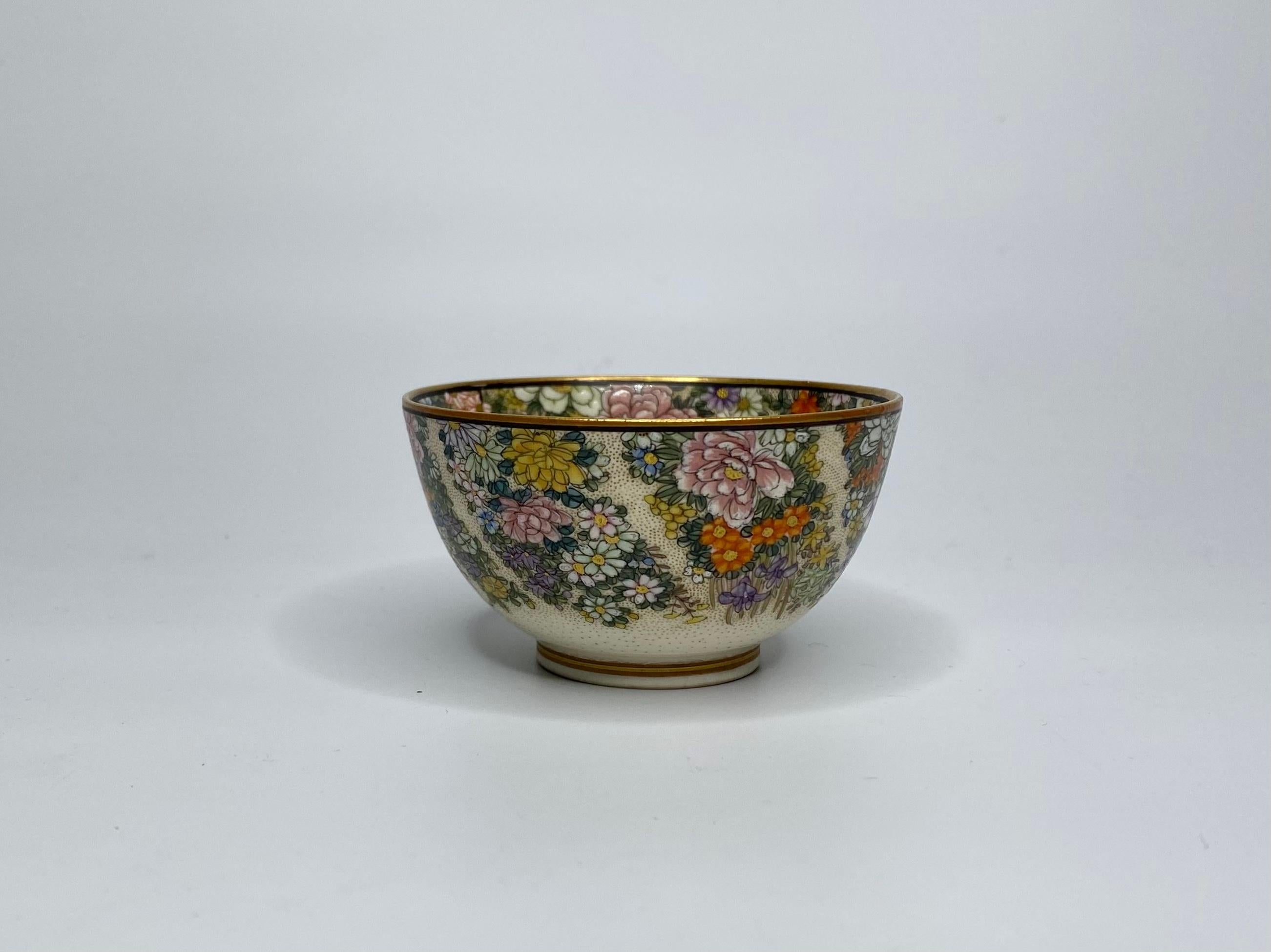 Satsuma pottery small bowl, Kinkozan, c. 1900, Meiji Period. Finely hand painted to the exterior, with spiralling bands of brightly enamelled flowers, on a gilt seed ground.
The interior painted with a dense band of flowers, around three