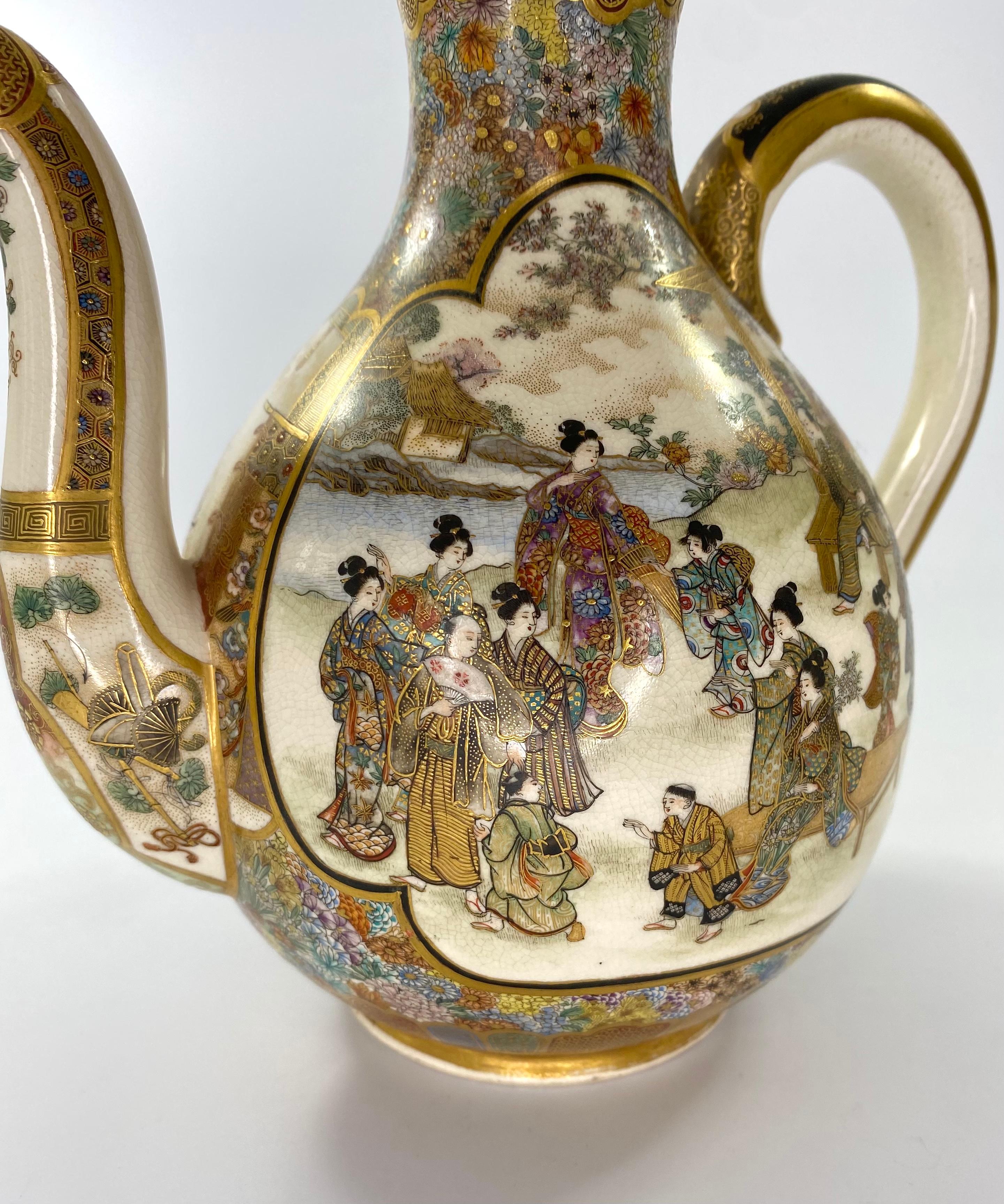 A fine and large Satsuma pottery sake ewer, painted by Ryozan Okamoto, for the Yasuda Company, Meiji Period (1868 -1912). Beautifully hand painted to either side, with two large foliate shaped panels, containing scenes of numerous figures, at