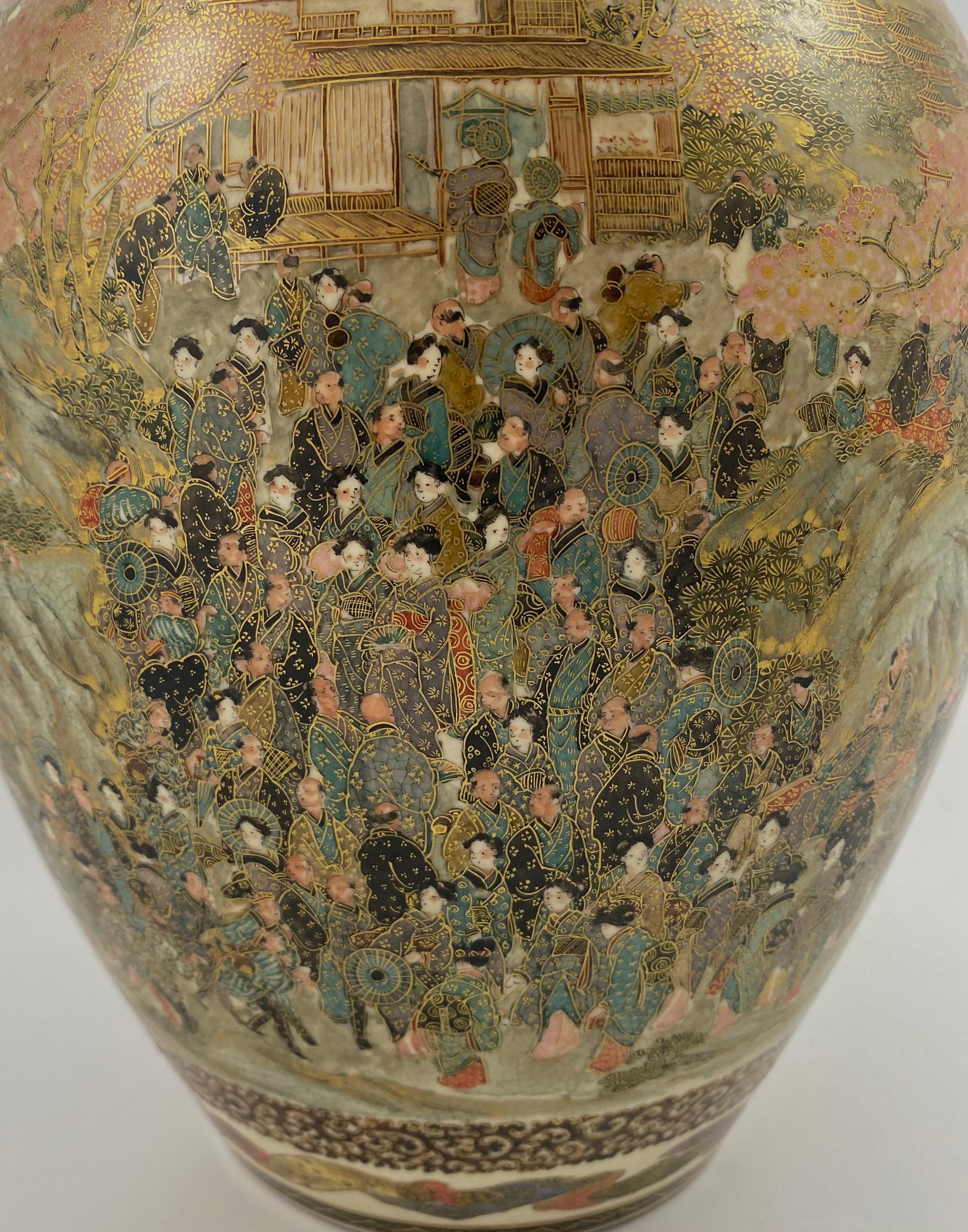 Satsuma pottery vase, of large size, signed Zenkozan, Meiji Period. Painted to the body with crowds of people attending a Festival, in extensive gardens, and before pavilions. Groups of people can be seen chatting beneath trees flowering with cherry