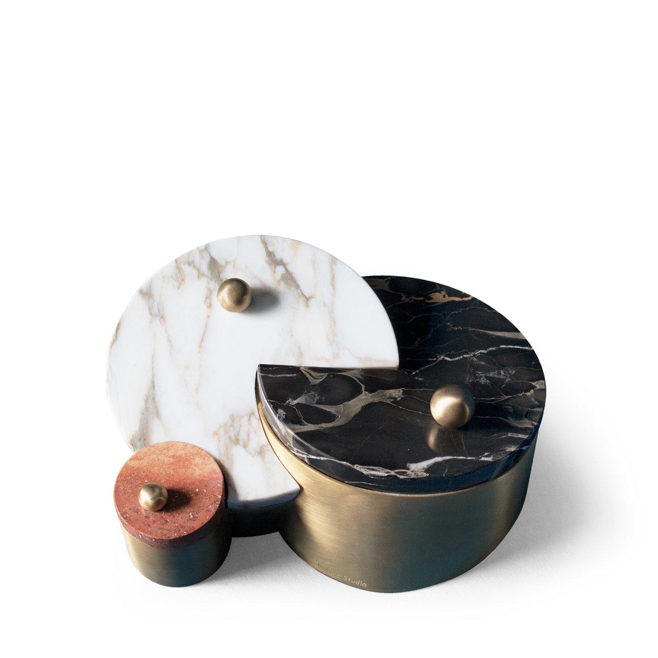 The box’s interlocking shapes reference this year’s exceptional planetary conjunction between Saturn and Pluto. The Saturn and Pluto box features three brass round compartments with tops in calacatta, red travertine and portoro marble.

Handmade in