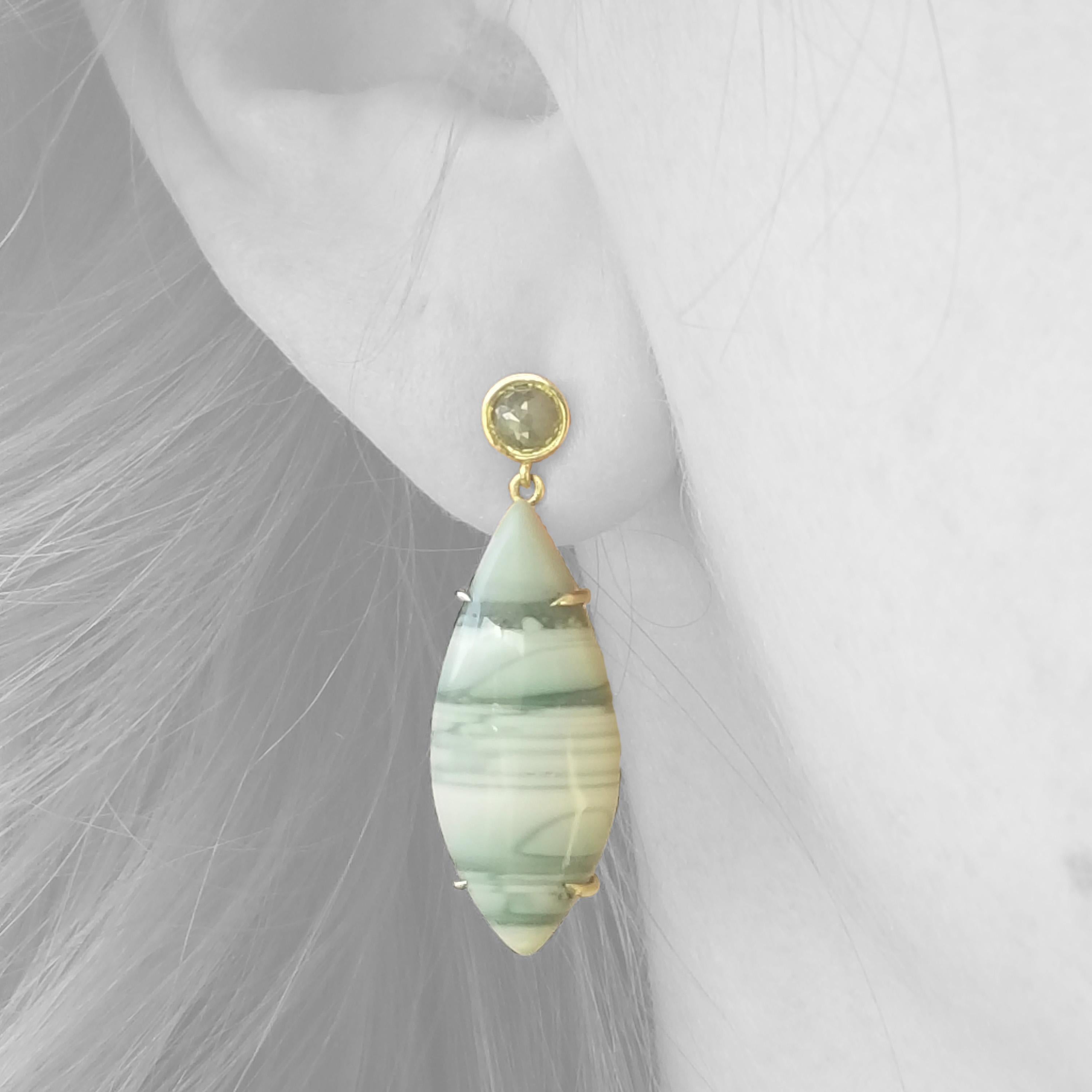 The enchanting and graceful natural pattern of the Saturn Chalcedony is a beautiful place to start a jewelry design. The delicate navette shapes are transformed into the perfect earring drops, and the accompanying silver/green translucent rose cut