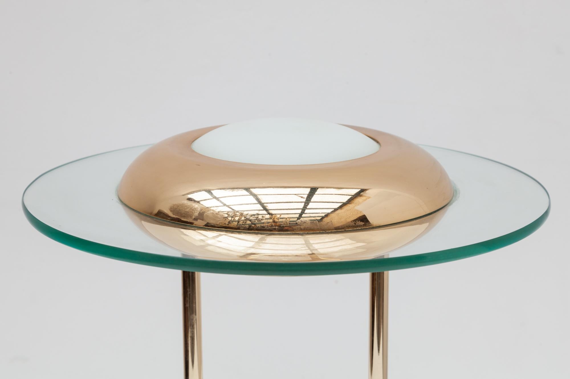 1980s desk, table lamp in the style of Robert Sonneman. A glass ring circles the brass and milk glass shade. Dimmable.