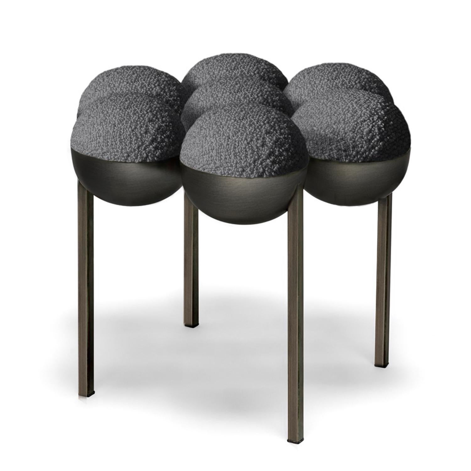 The small Saturn pouffe utilises the same gathered bilboquet seat construction as Saturn chair. The sumptuously undulating seat instantly appeals with its invitingly upholstered comfort, while the graceful supporting metalwork establishes the sense