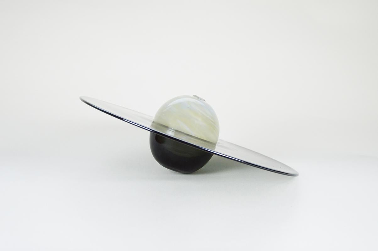 Stielvase Saturn von Atelier George
Abmessungen: Ø 35 x H 10 cm
MATERIALIEN: Mundgeblasenes Glas

Das Atelier George ist ein französisches Design- und Glasbläserstudio. Jedes Stück ist handgefertigt und wird mit der Technik der Heißglasherstellung