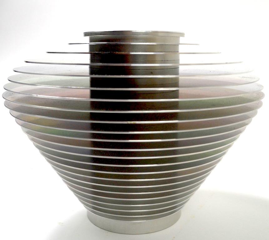 Saturn vase by Avedis Baghsarian constructed of stacked graduated aluminum rings surrounding a cylindrical aluminum core. This series was designed to come apart and be reassembled in almost infinite configurations. Original, clean condition, fully
