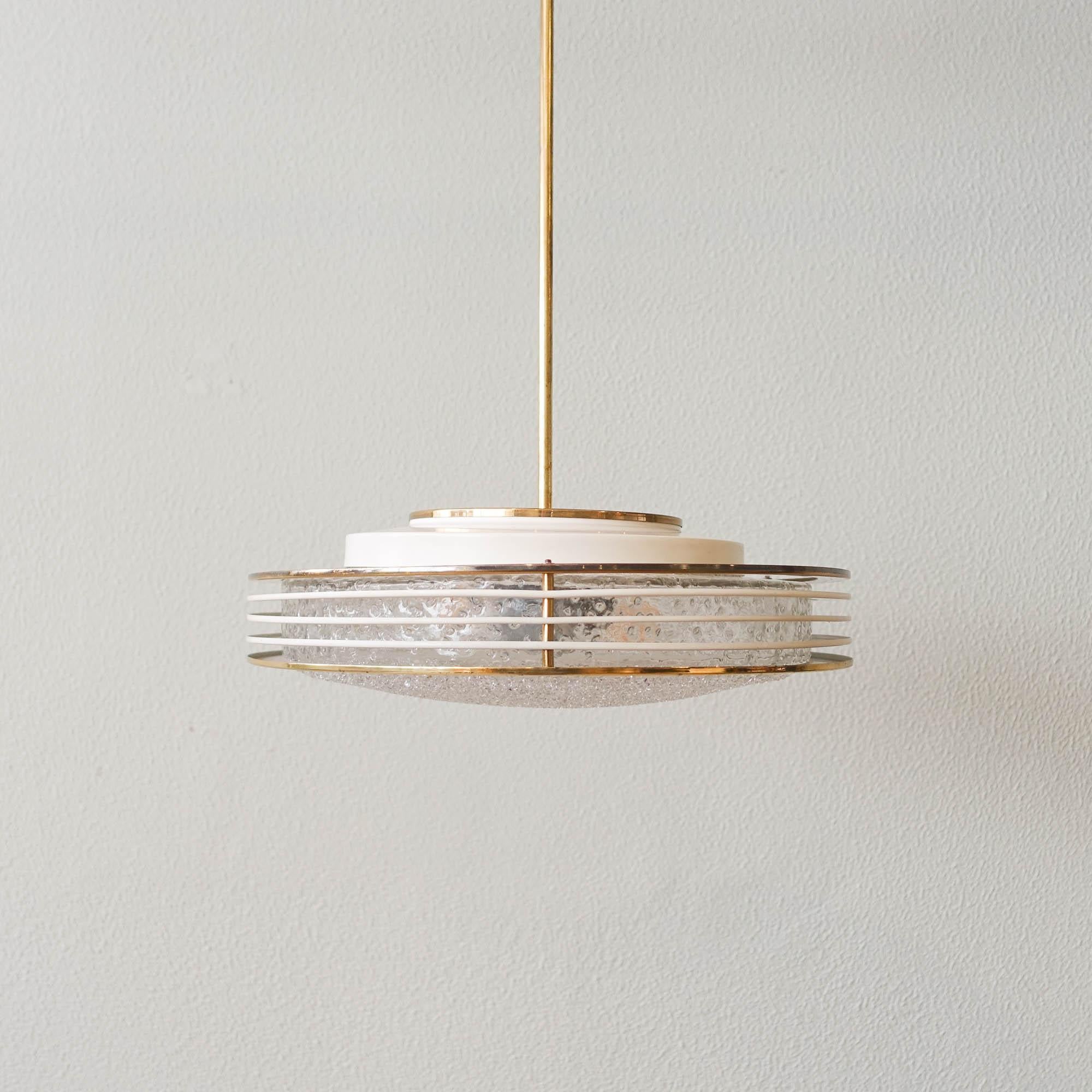 This Saturno ceiling lamp was produced by Doria Leuchten, in Germany, during the 1960s. The light has a round frosted glass disk with a high gloss brass ring around it and four brass rings over the first one. In very good vintage condition, with the