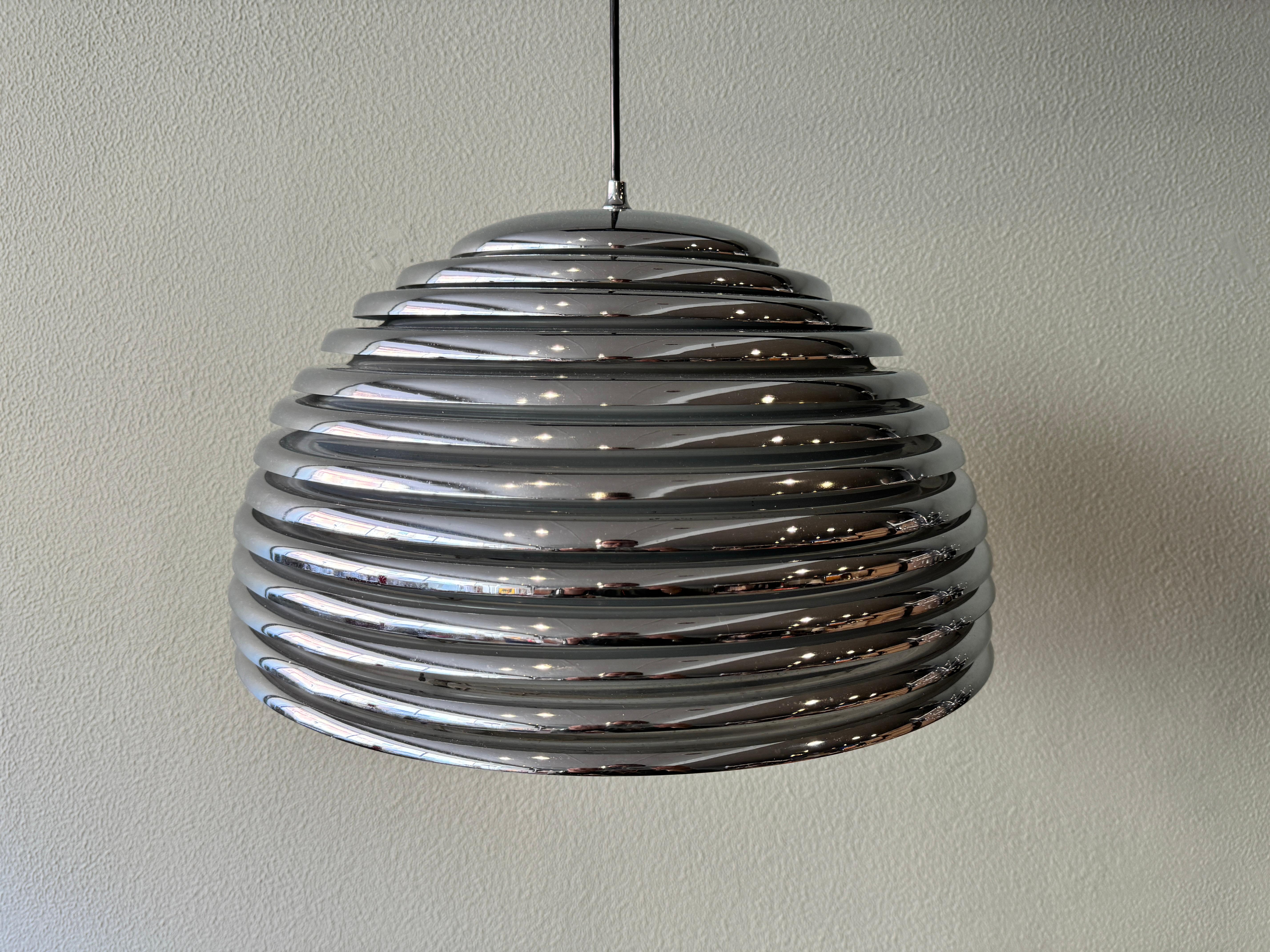 Introducing the Saturno Pendant Lamp by Kazuo Motozawa, a vintage piece from the 1970's designed for Staff Leuchten in Germany. This lamp is made of chrome-plated steel and has a 30 cm height and 50 cm diameter chromed metal shade with 13 round