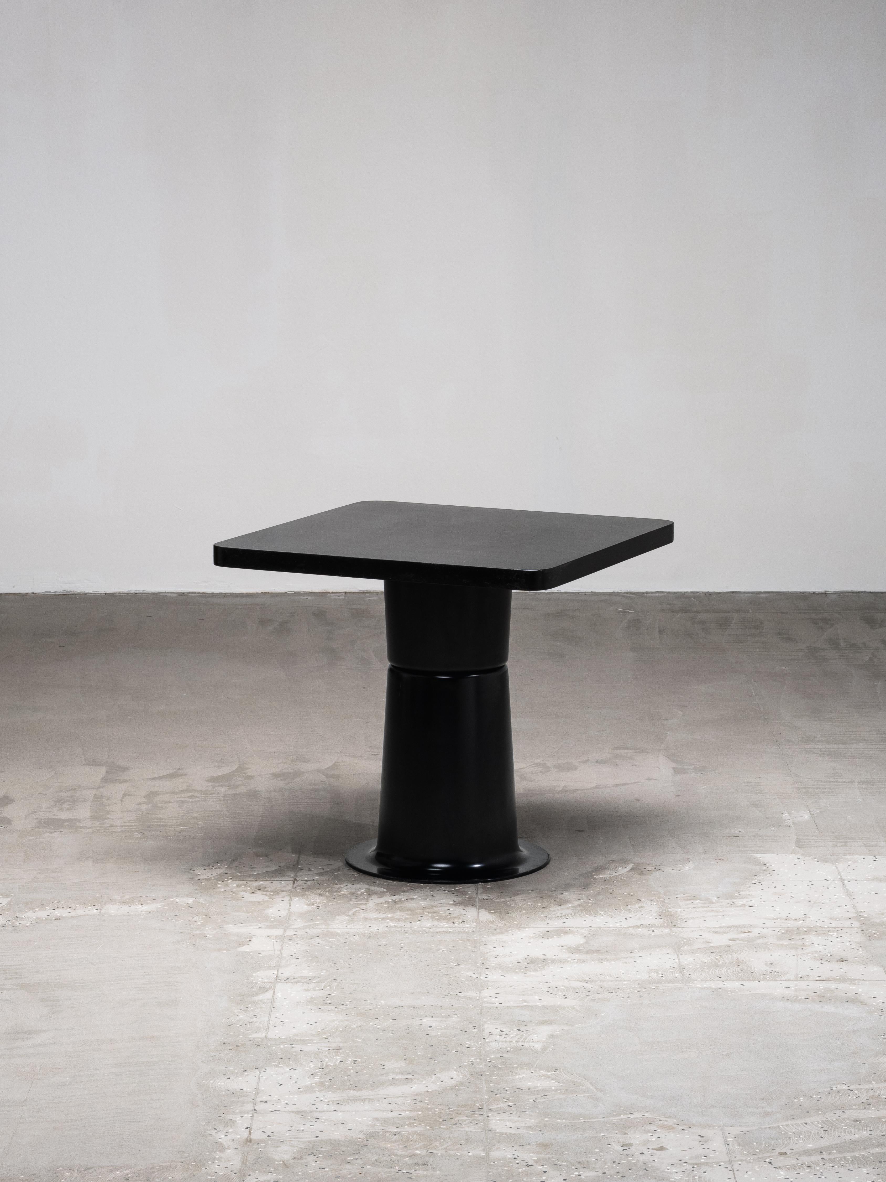 A sculptural side table from Yrjö Kukkapuro’s ‘Saturnus’ series, produced by Haimi in the 1970s. The table features a square top with rounded corners set on a boldly flared pedestal base, all finished in a deep, uniform black. Its clean geometry and