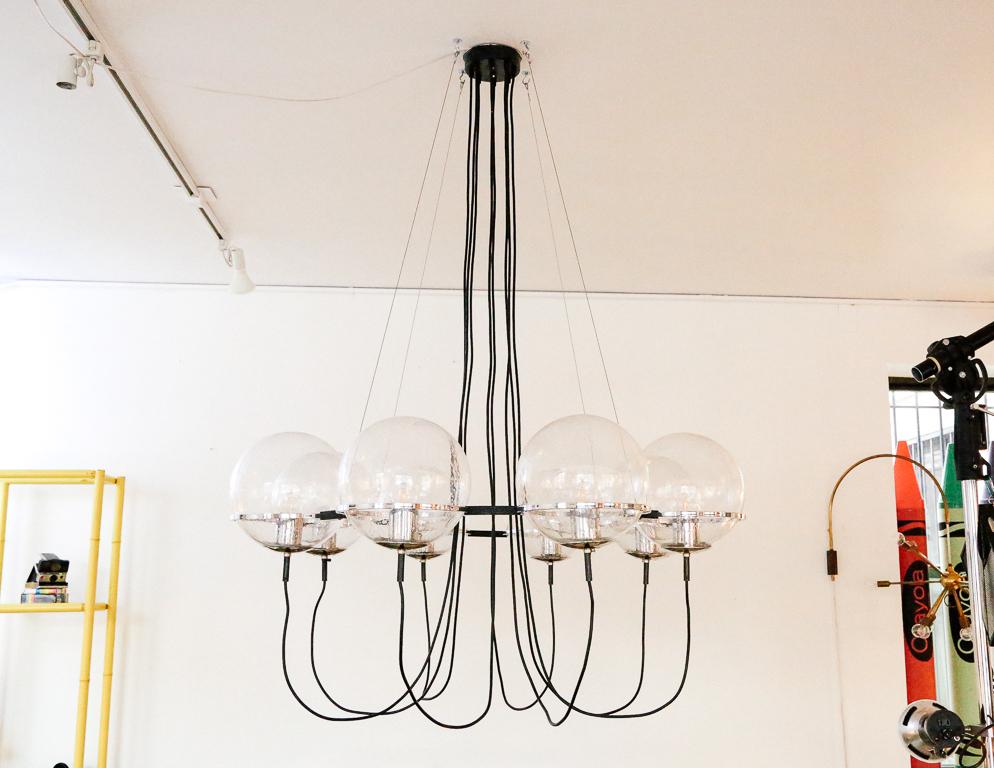 Extra large version of the ‘Saturnus’ chandelier by RAAK of the Netherlands. Eight blown glass globe shades with tiny air bubbles suspended by a black and chrome ring. Suspended by four stainless steel cables.