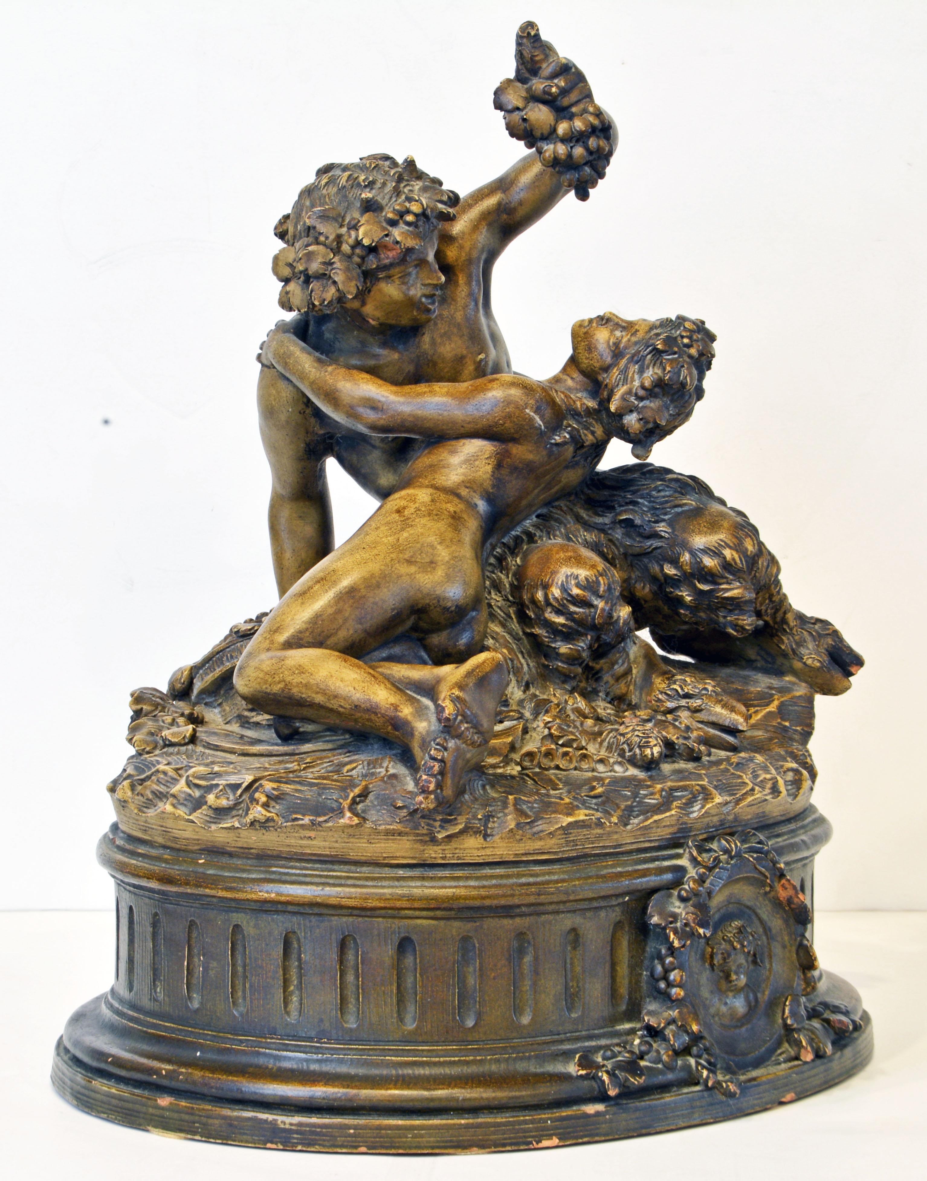 A large patinated terracotta sculpture depicting a youang Satyr playing with a Nymph on an oval base sculpted in the Louis XVI style. Work of the late nineteenth century after Claude Michel dit Clodion (1738-1814).