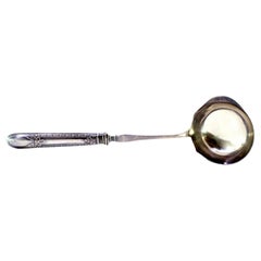 Sauce ladle w/ silver-lined handle w/ bows 
trim surrounding monogram card