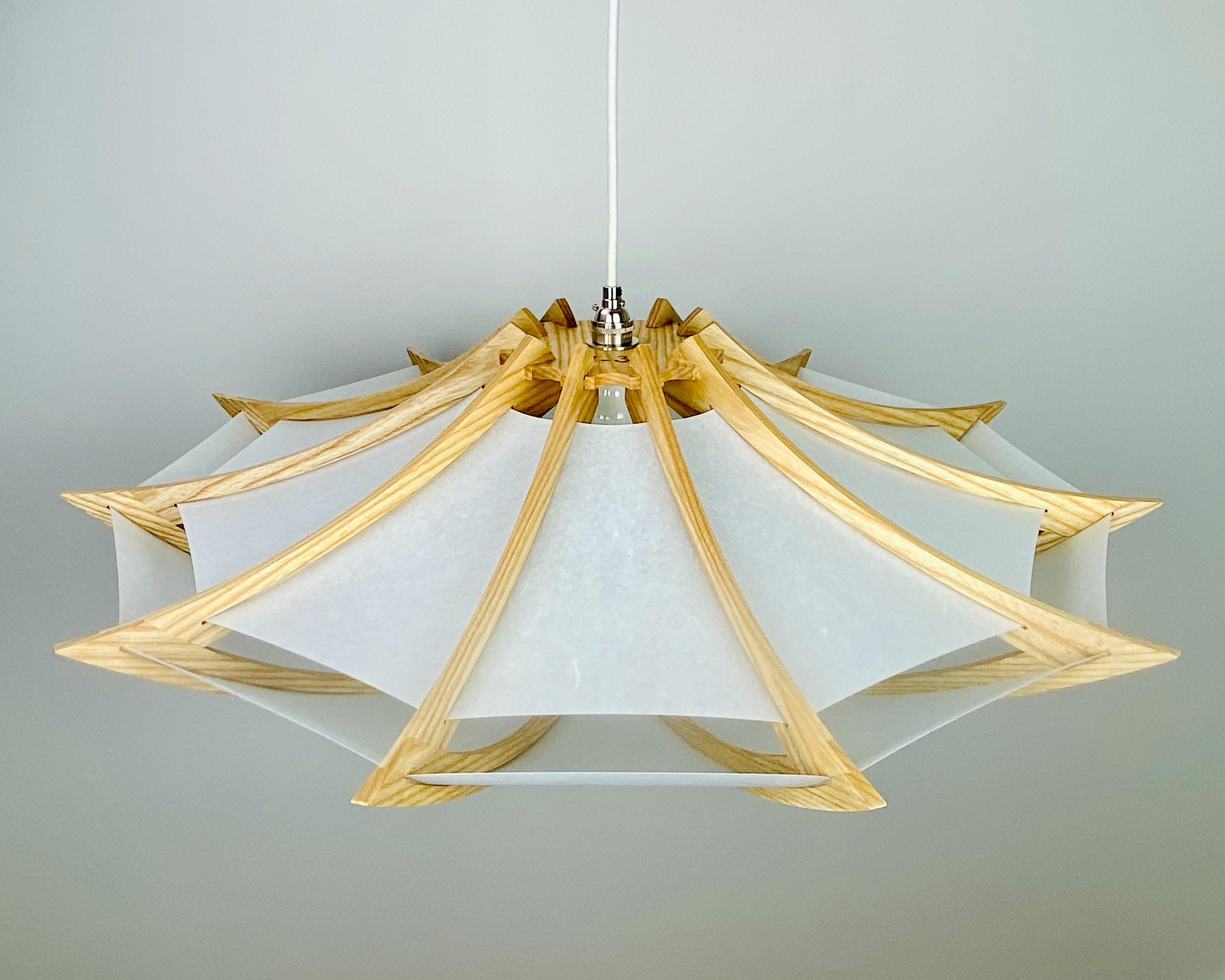 This wooden light incorporates elements of mid-century modern design and Japanese art. The design is clean and contemporary, and the curves evoke natural forms. Each light is made with your choice of wood: ash, ebonized ash, walnut, or cherry. Shown