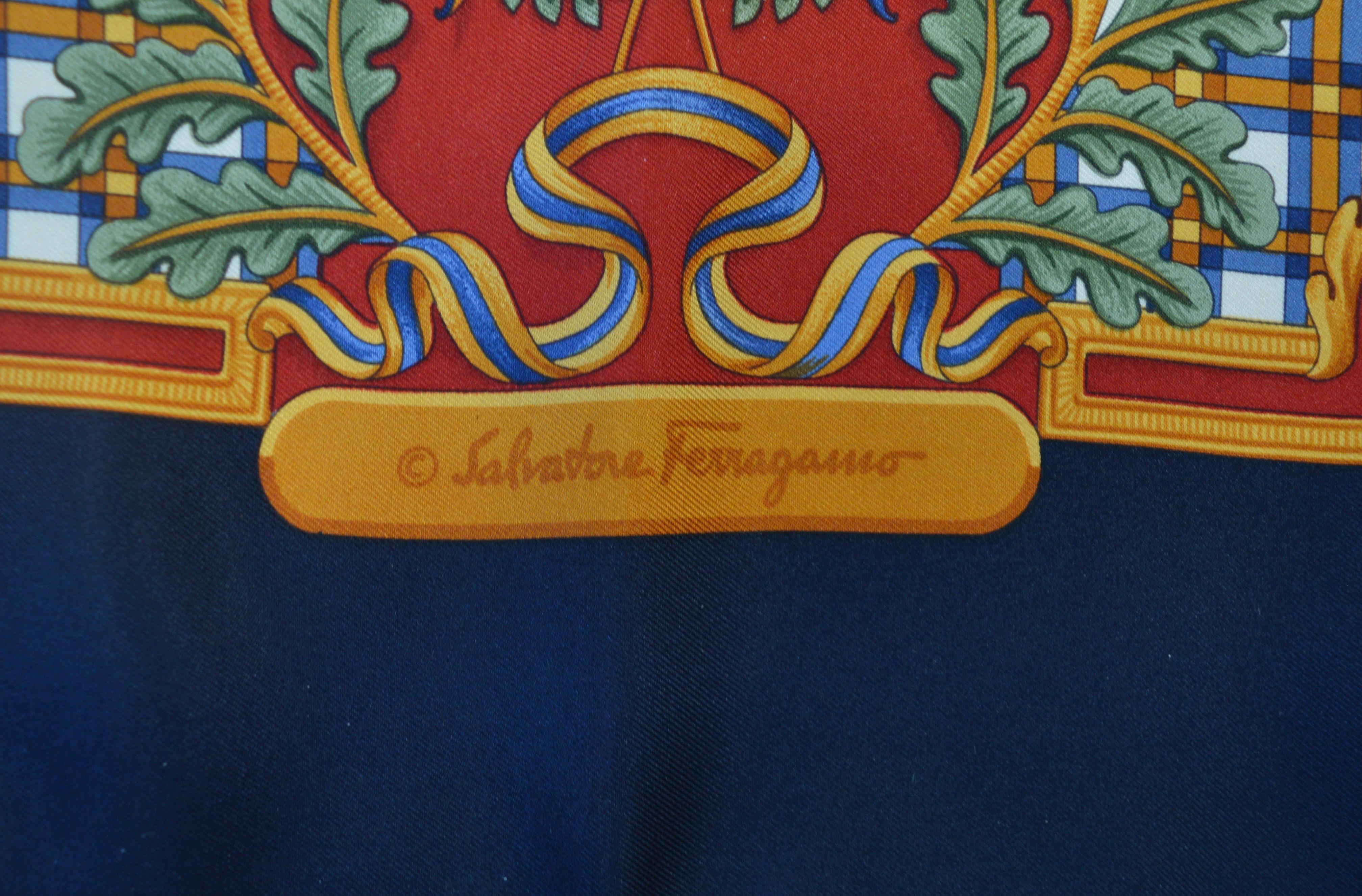 A gorgeous Salvatore Ferragamo silk scarf with scenes of summer sports, polo, tennis, golf and fencing intertwined with bows, ribbons, oakleaves and climbing ivy on a dark red ground with navy blue border. 
Printed Salvatore Ferragamo in the silk,