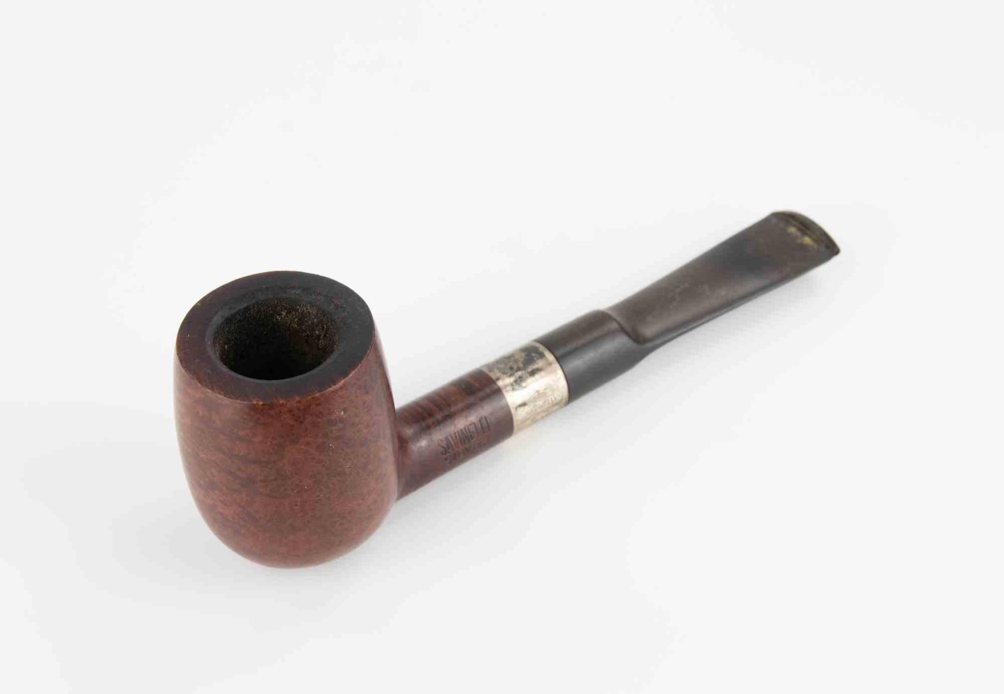 Un ottimo esempio di artigianato italiano da parte di uno dei nomi più rispettati nella produzione di pipe. La pipa presenta una classica forma diritta a biliardo, semplice ma elegante, che permette alle venature naturali della radica di essere