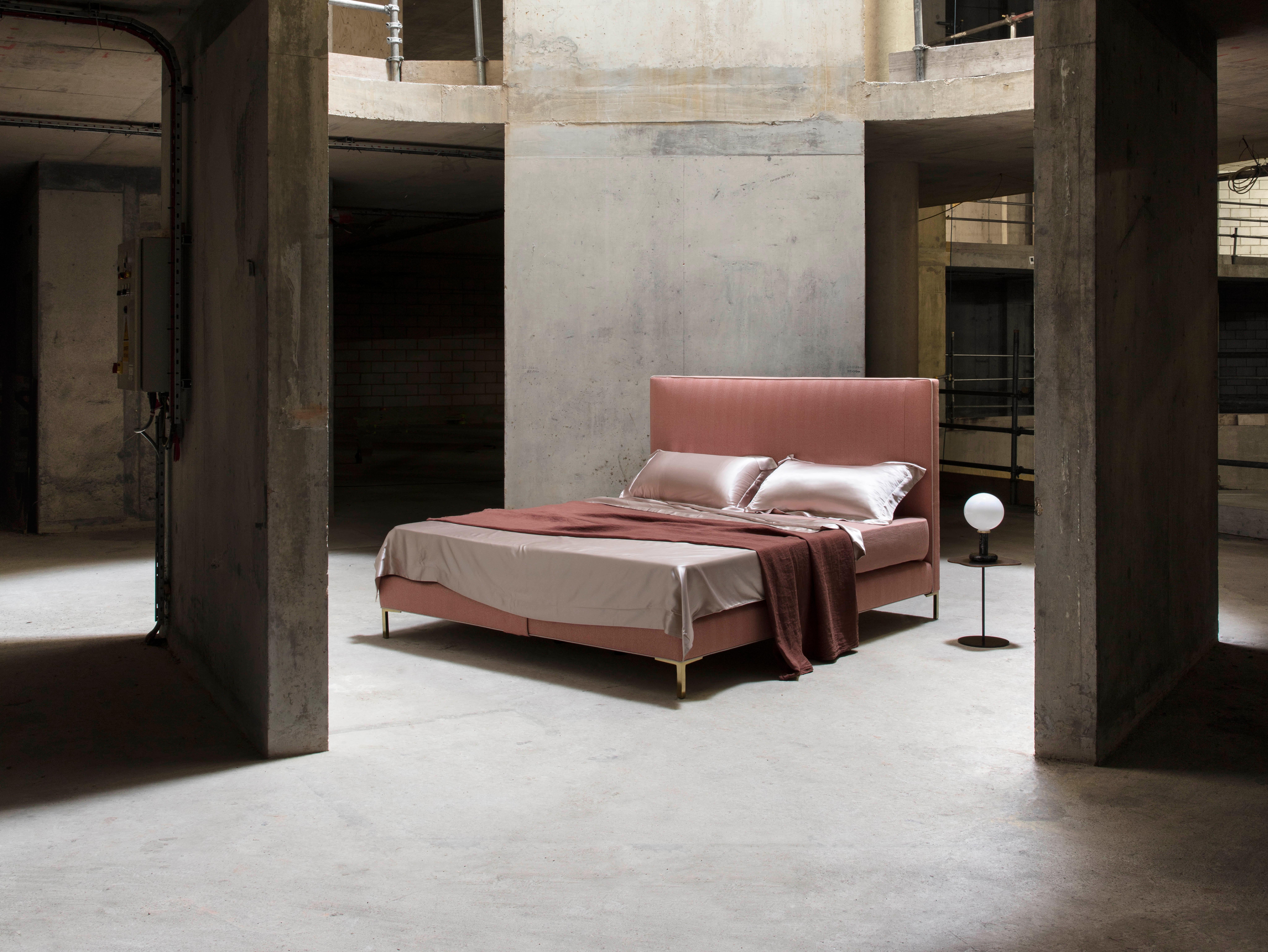 A Classic Savoir house design. The Harlech is a beautifully simple bed that adopts an angular, streamlined silhouette. The headboard and base are upholstered in a textured blush pink Holland & Sherry fabric that oozes femininity. Featuring an