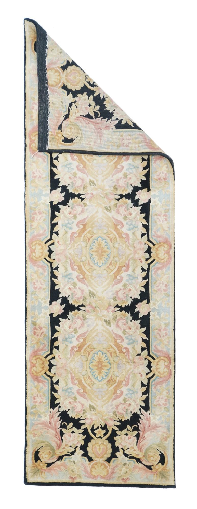 Savonnerie runner 2'6'' x 8'. The black field features three connected squared elliptical cartouche medallions with scrolled salmon centres, and leaf edges. Broken cream border with straw scallop shell intrusions. Medium weave, cotton foundation. We