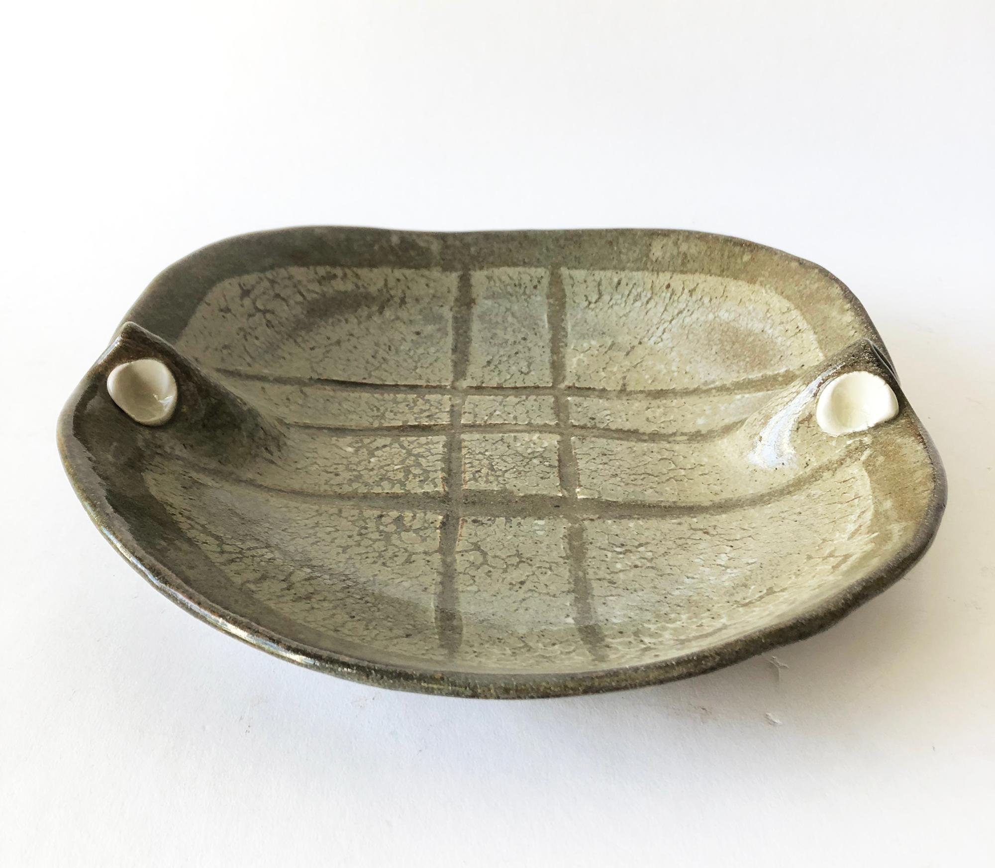 Stoneware open bowl with porcelain accents and grid design created by artist Sawako. Bowl measures 11