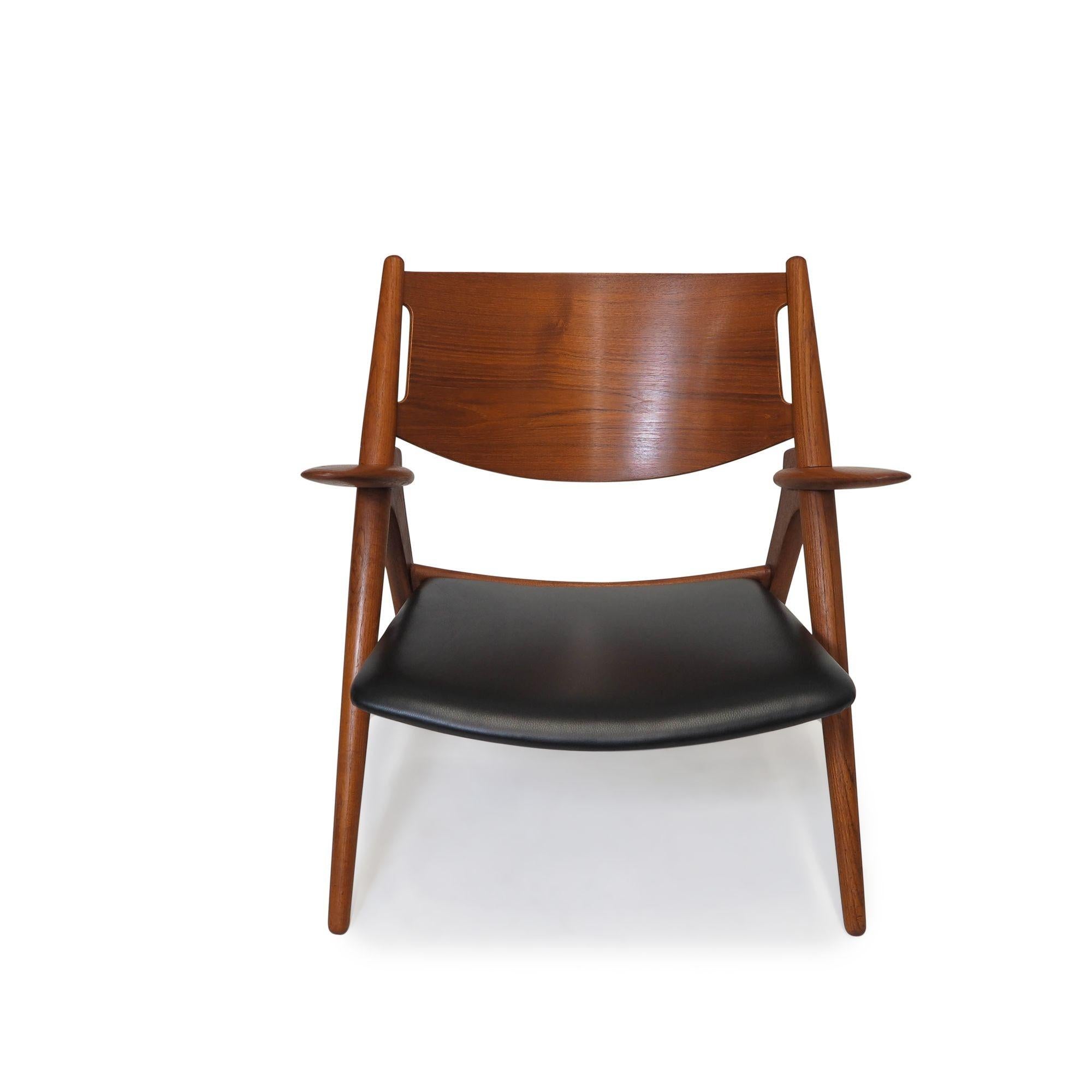 Model CH28, “Sawbuck” Danish lounge chair designed by Hans Wegner and produced by Carl Hansen in Denmark, 1951. The chair features a simple and elegant design, with a distinctive X-shaped frame that gives it a modern, yet timeless, appearance. The