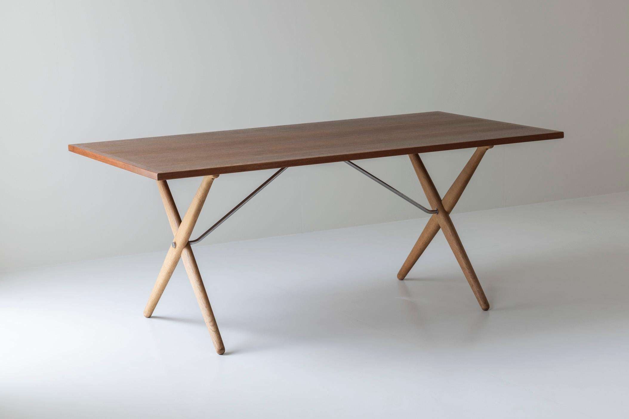 Table de salle à manger 'Sawbuck' ou 'AT 303' de Hans Wegner pour Andreas Tuck, Danemark, années 1950. Cette table de salle à manger à pieds croisés est dotée d'un plateau en teck, d'un cadre en chêne et d'un support chromé. Présenté dans son état