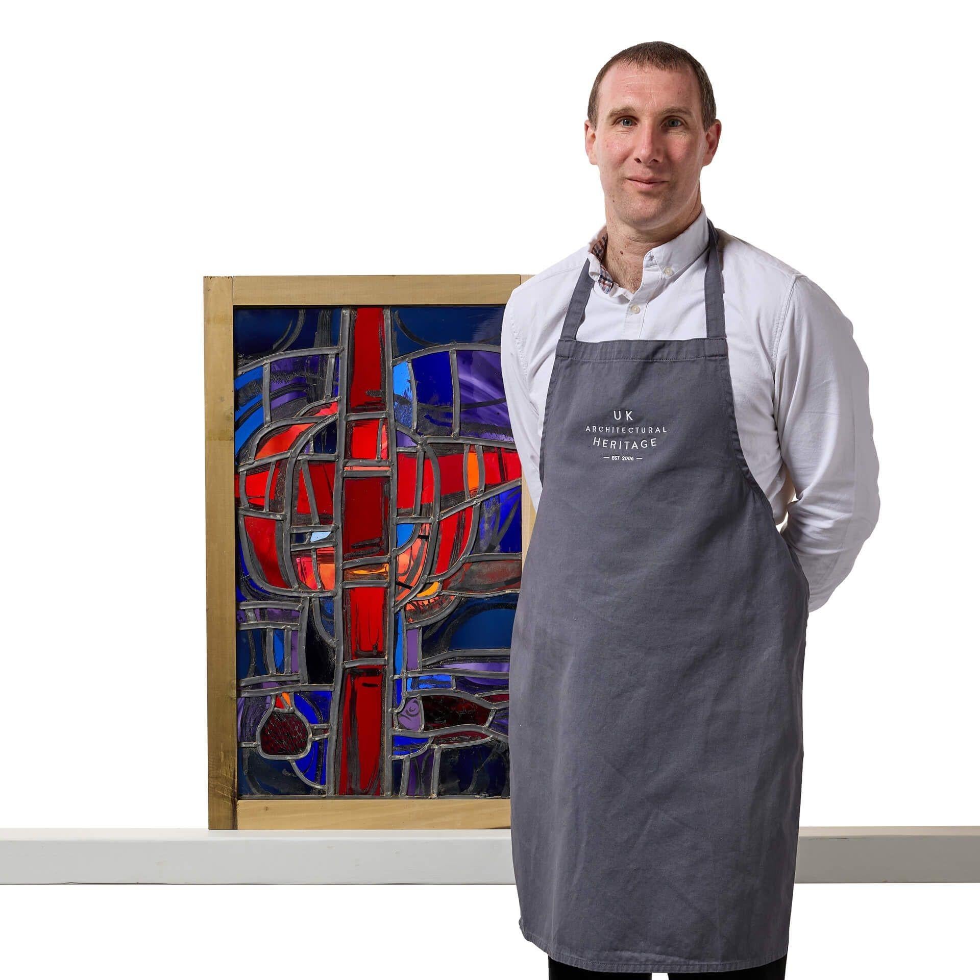A vibrant stained glass window with a contemporary religious design from the workshops of British stained-glass artist, Sax Shaw.

Beautifully made using glass in shades of red, blue and purple, this abstract stained glass window panel centres