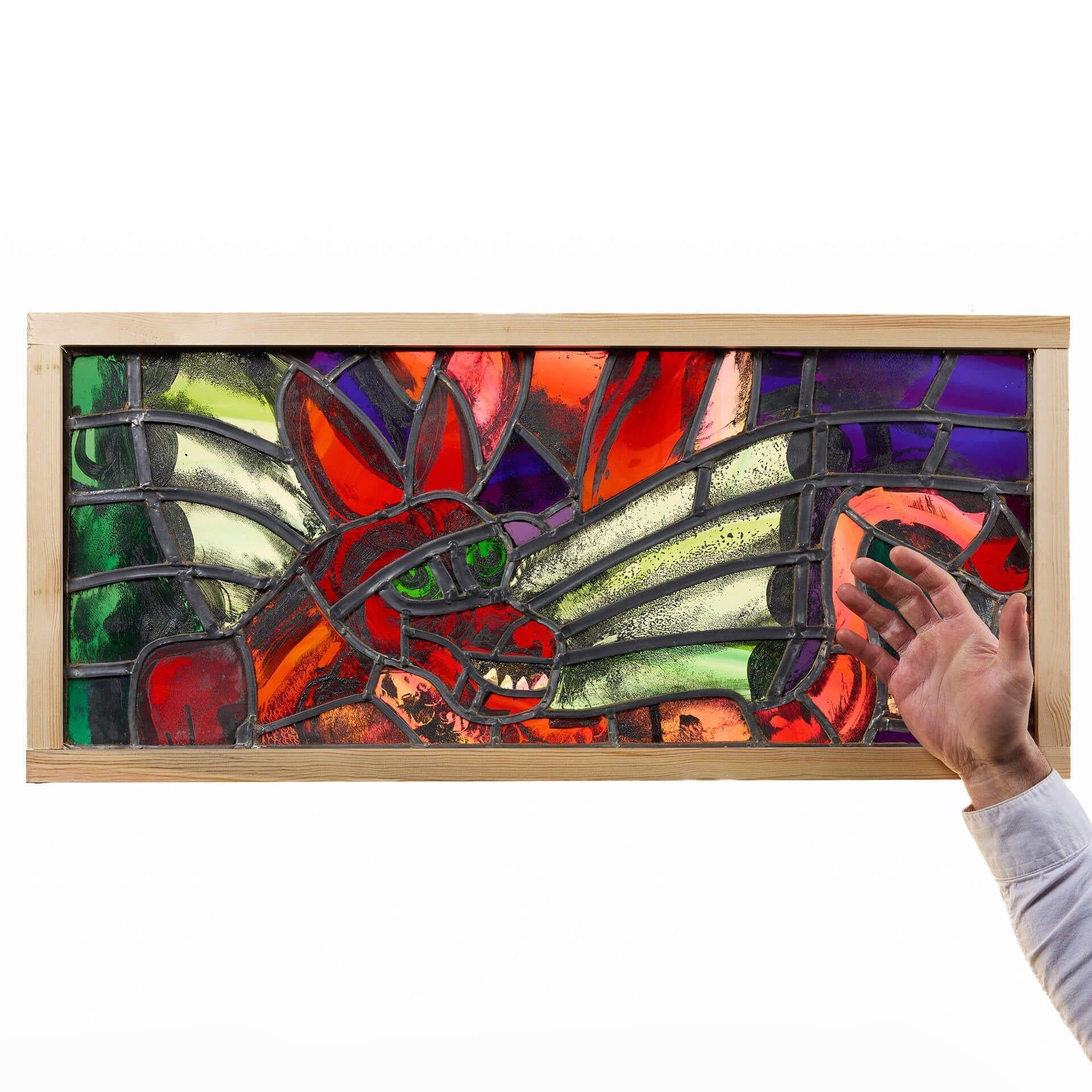 A vibrant mythological themed stained glass window depicting a red dragon from the workshops of British stained-glass artist, Sax Shaw.
 
Beautifully made using glass in shades of red, green, blue and purple, this contemporary stained glass window