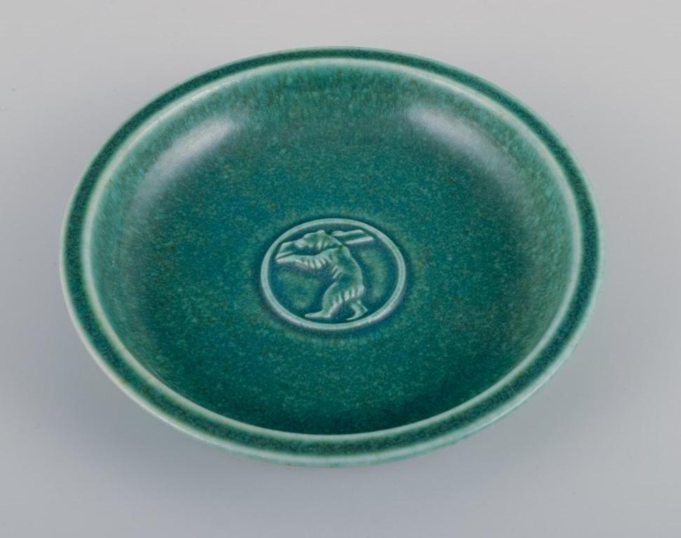 Saxbo, Denmark. Small ceramic bowl featuring a motif of a standing bear.
Glaze in green tones.
Mid-20th century.
Marked.
Excellent condition.
Dimensions: Diameter 15.3 cm x Height 3.0 cm.