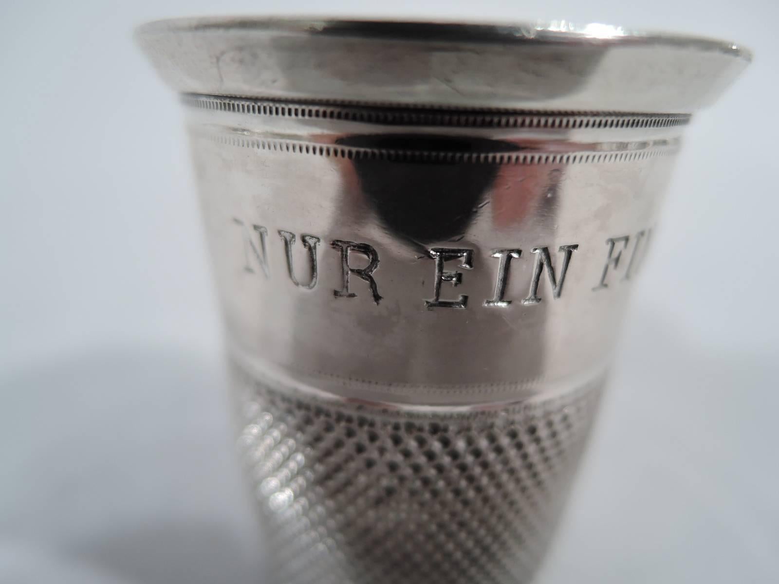 Antique German 835 silver novelty shot glass. Honeycomb ground and plain band with the usual joke “Only a thimble full” in German (Nur ein Fingerhut voll). Hallmarked.