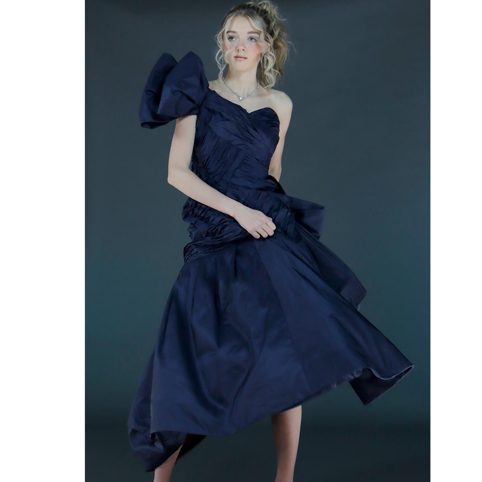 This is a stunning Scaasi Boutique 1980's vintage blue silk taffeta one shoulder evening gown. The high low silhouette, bows and unique criss cross pleating make this dress an incredible piece to add to any wardrobe or collection. The sheath upper