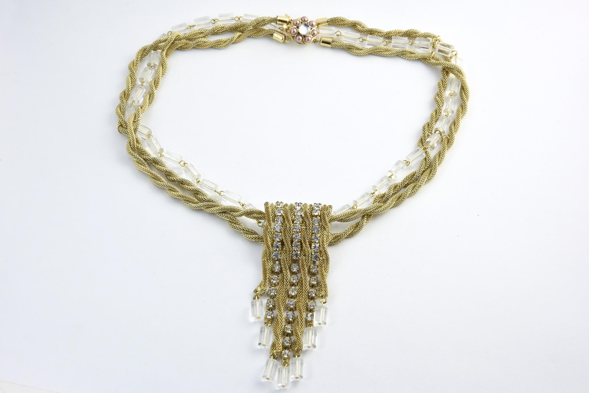 Scassi goldtone rope necklace surrounding Lucite cylinders and square rhinestones. The clasp has a rhinestone center surrounded by seven faux-pearls. Center rhinestone piece, 4.25