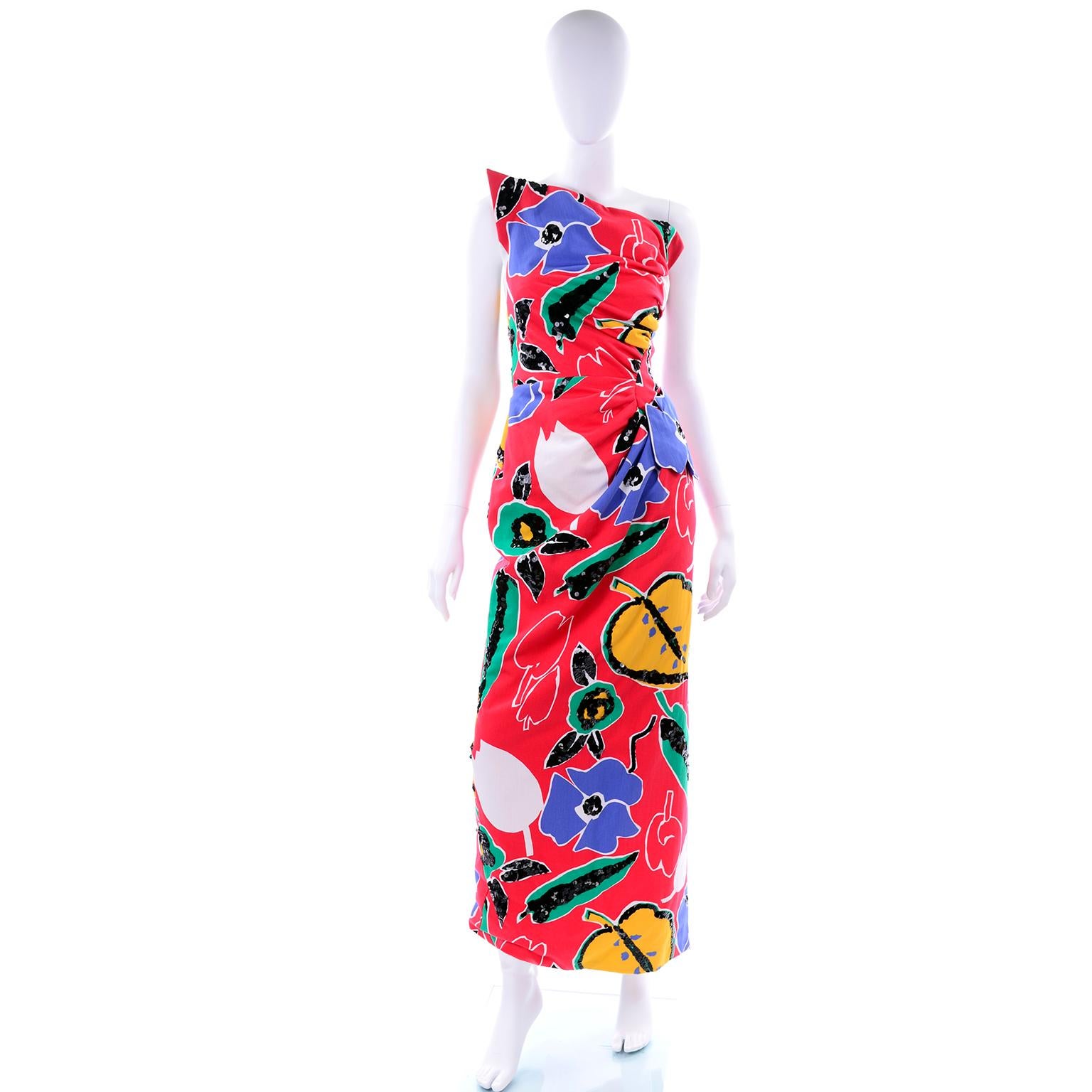 This is a stunning vintage evening dress from Arnold Scaasi in a gorgeous red, blue, yellow, green and white cotton floral print. This Scaasi boutique Summer evening gown is embellished with lovely sequins and we especially love the asymmetrical one