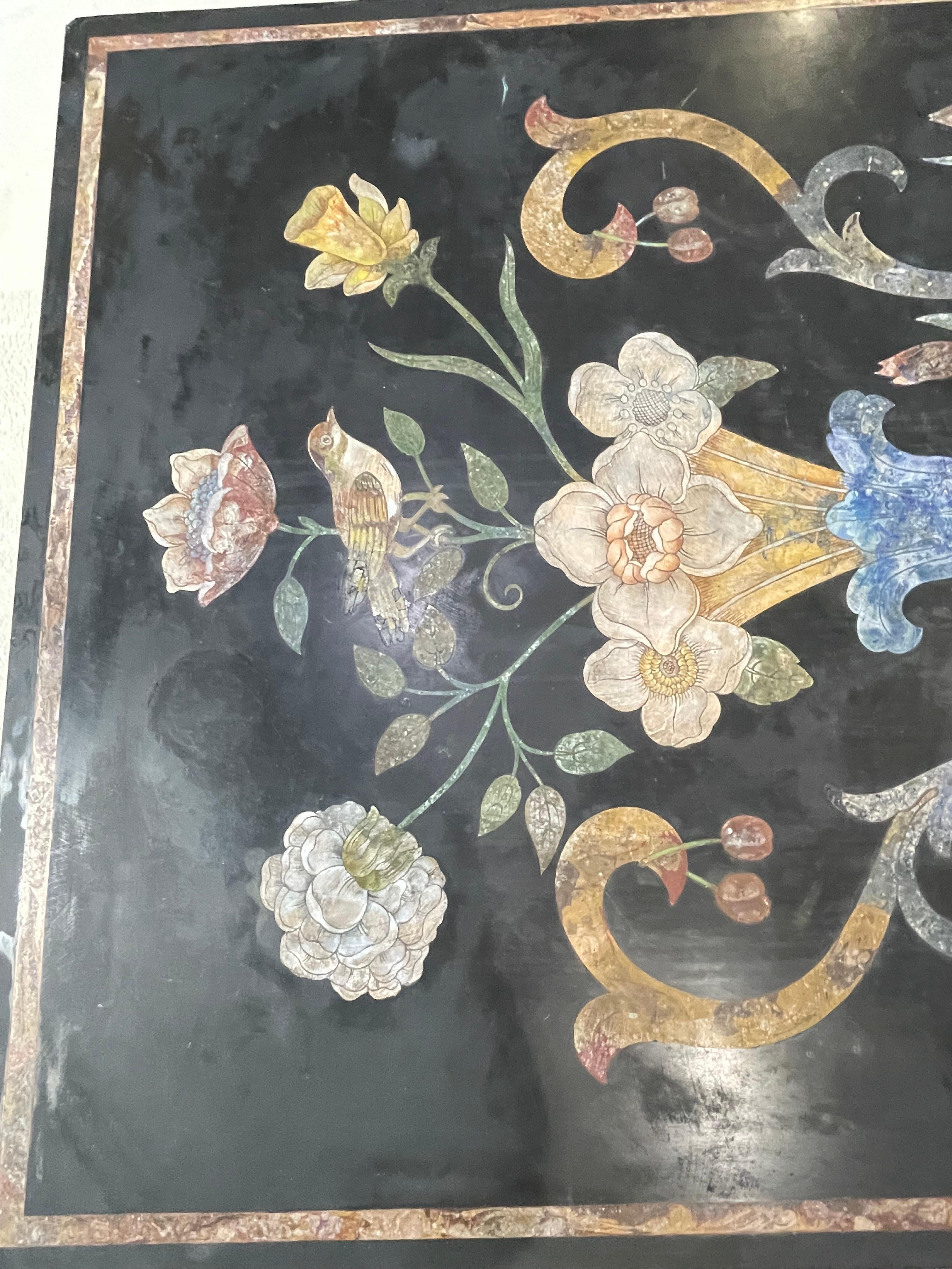 Table scagiola italienne polychrome représentant des fleurs, des feuillages, des cerises, des oiseaux et des ronces. Les couleurs sont une dégradation du jaune ocre, quelques notes de bleu et de rose agrémentent le tableau. Cette table scagiola