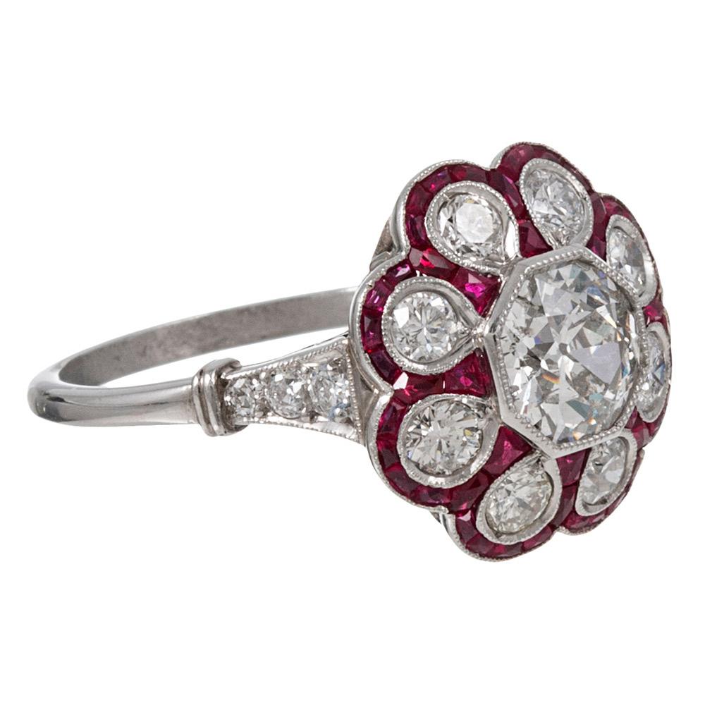 The design of the handmade mounting is centered upon an old European cut diamond solitaire set in an octagonal bezel and is framed by a scalloped edge with diamond “petals” and ruby accents. Indeed, it is a glorious creation! The major diamond