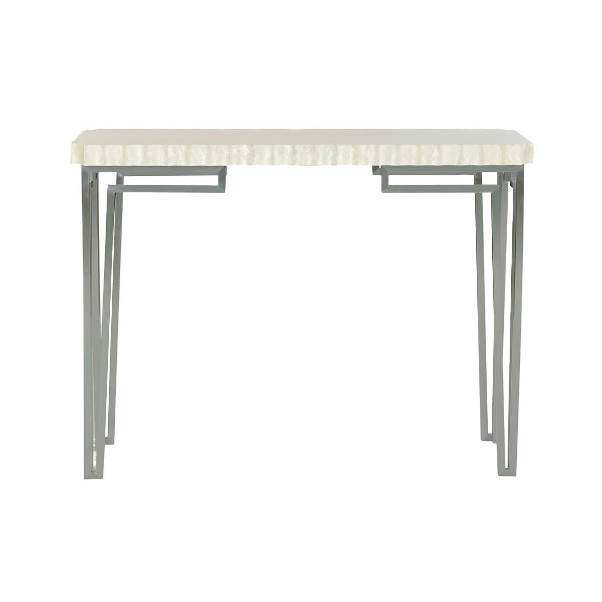 The scalloped rectangular top, finished in a striking ghost finish on wood, adds texture and refinement to any space. Supported by a sleek geometric metal base, this console table embodies the glamour and symmetry of Art Deco style.

Perfect for