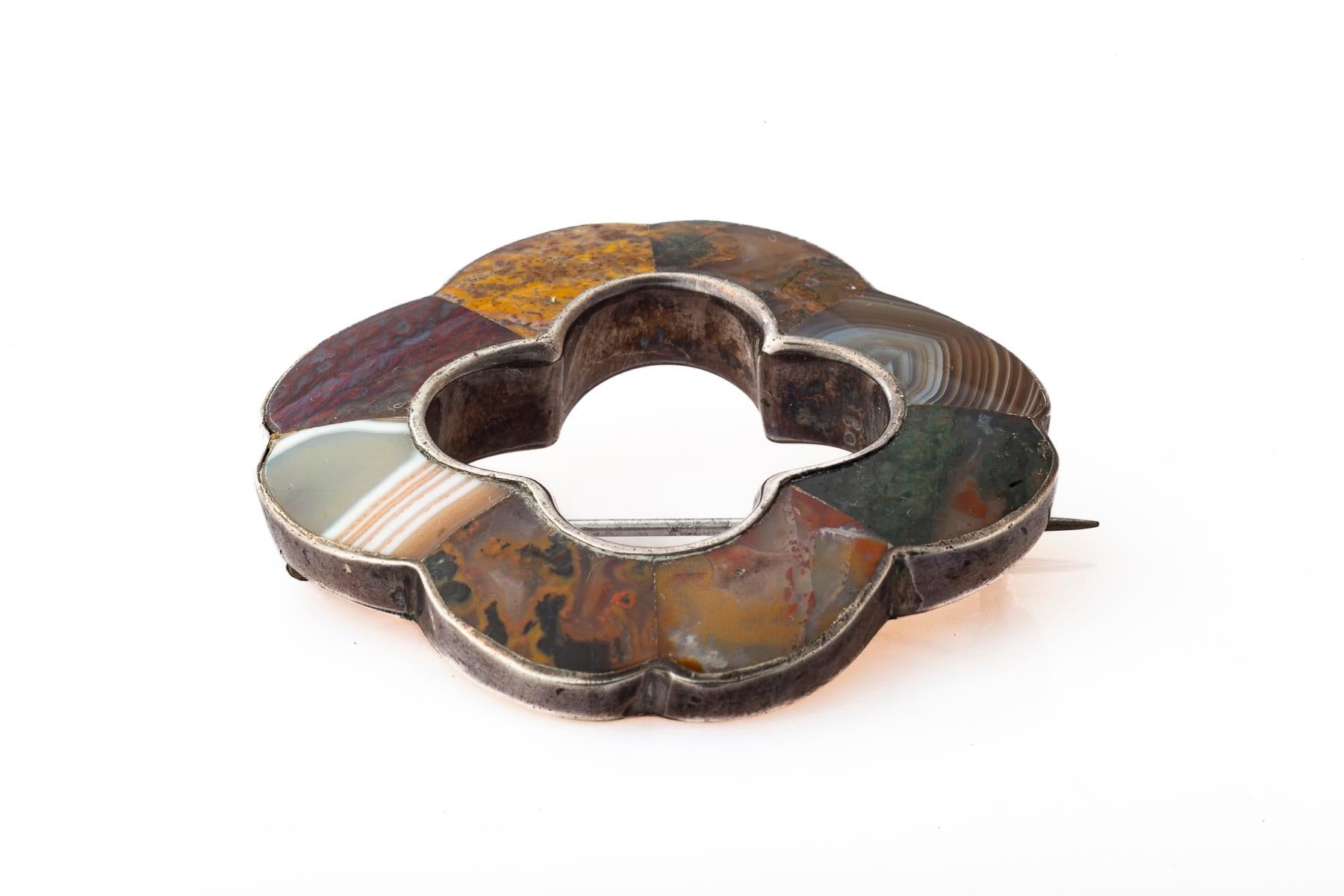 An unusual form of scalloped silver set with a mix of Scottish equally unusual. there is banded montrose agate, mustard agates, and bloodstone all with mixed coloration and texture.
Made c. 1860-1880 . An open clover is the center. My favorite