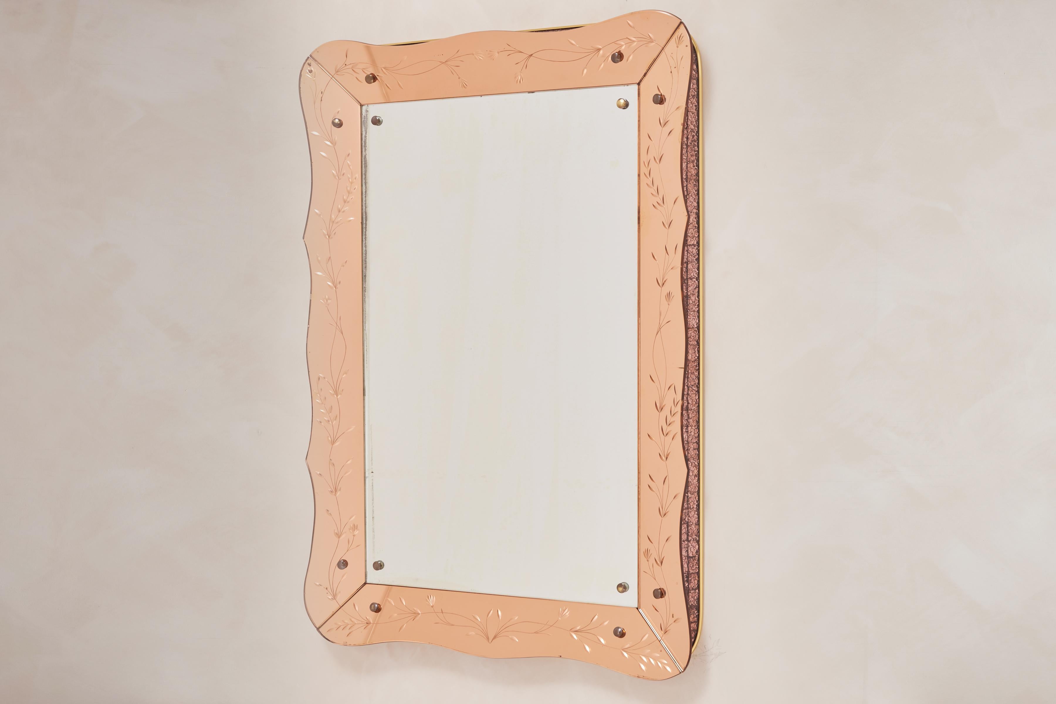 Stunning Cristal Arte Mirror with scallop shape and rose colored crystal glass that is etched with botanical vine.  

The sides of the frame are inset with hand-cut rose colored mosaic glass pieces bordering around the frame. mosaic 

Absolutely