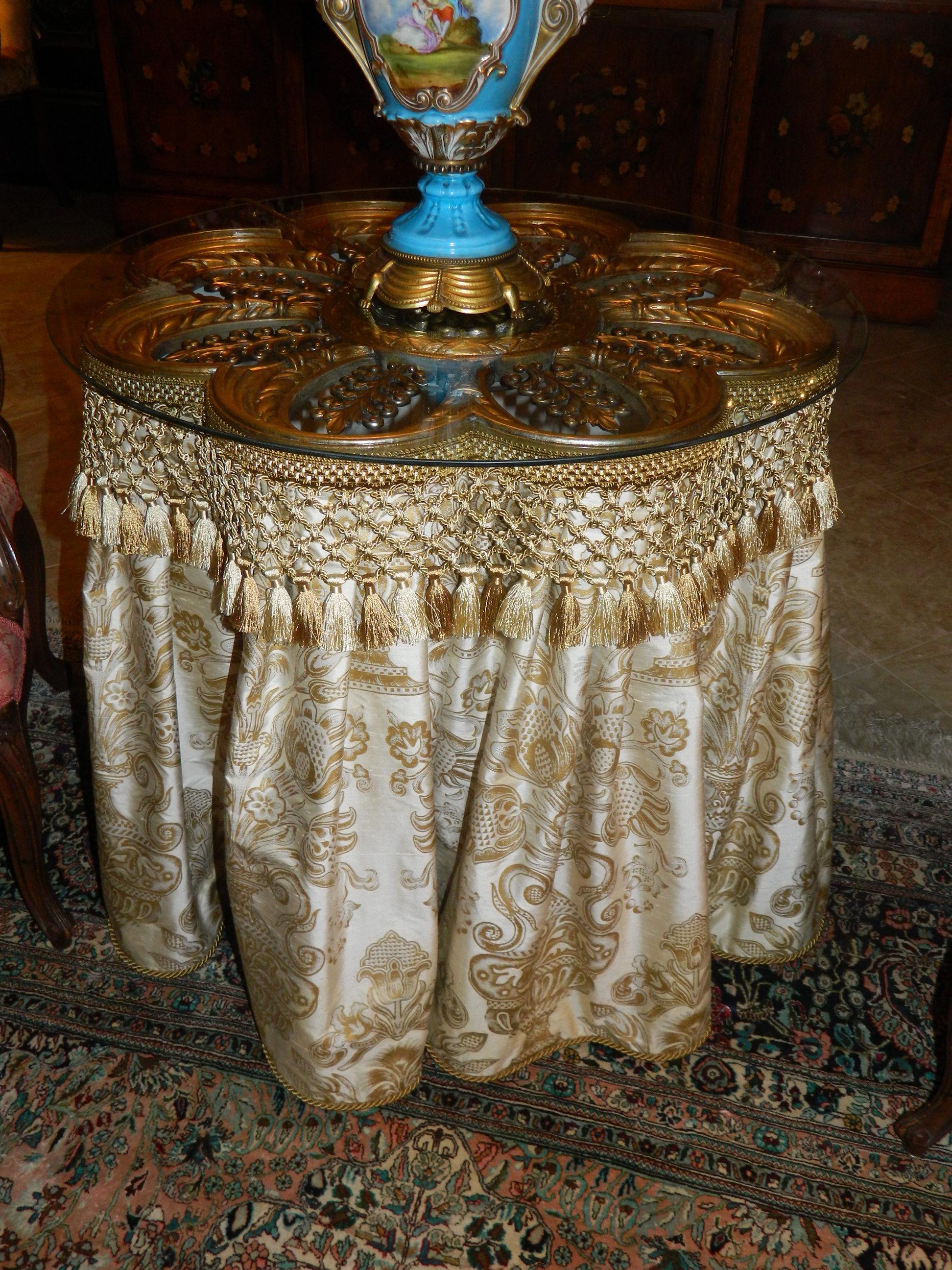 20th century scalloped gold painted metal pedestal table with a silk fabric skirt.