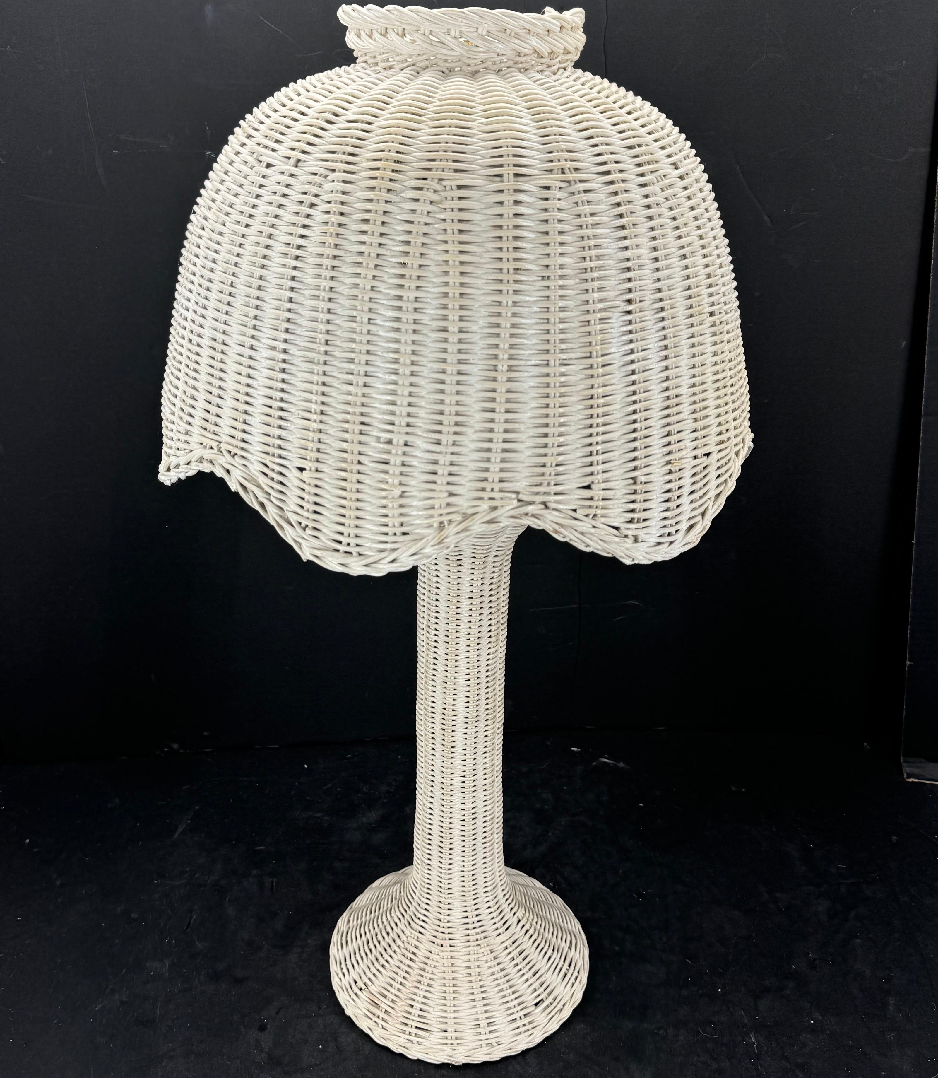 Classic Mid-Century Table Lamp from the 1960's. This charming wicker lamp features a round base with a fantastic scalloped shade that would add a Hollywood regency vibe sitting on a dressing table or bedside table. 