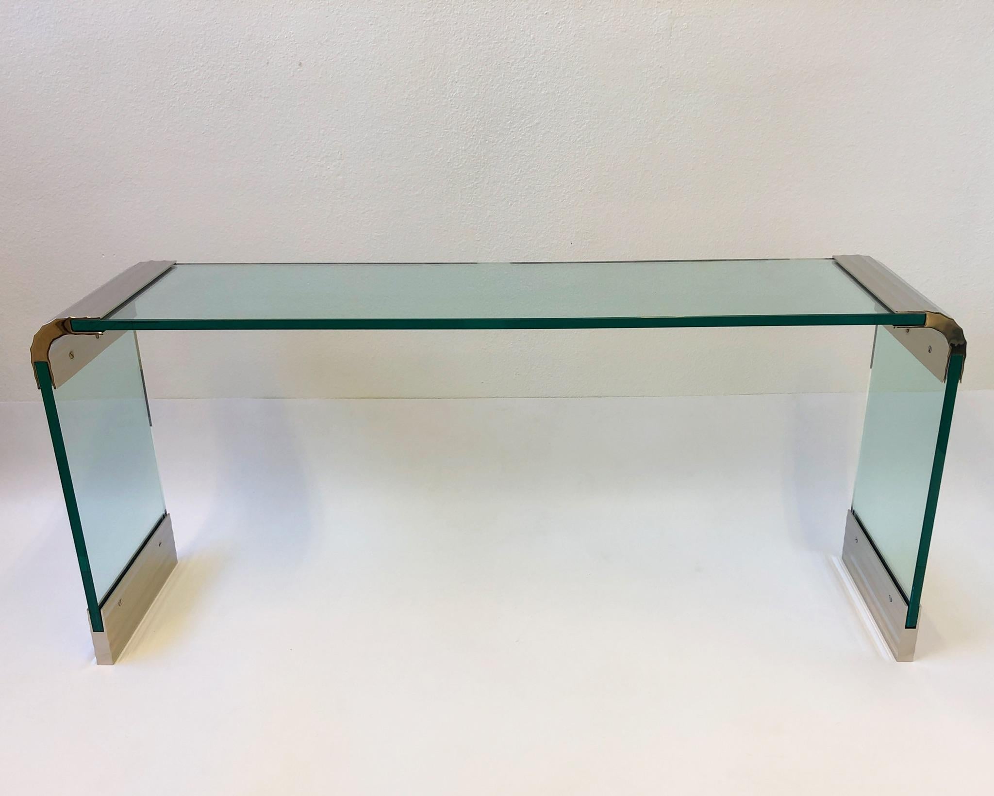 A spectacular scalloped polish nickel and glass waterfall console table designed by Leon Rosen for Pace collection in the 1970s. The table has new 3/4” thick glass and brackets have been newly nickel plated. If you want different length let us