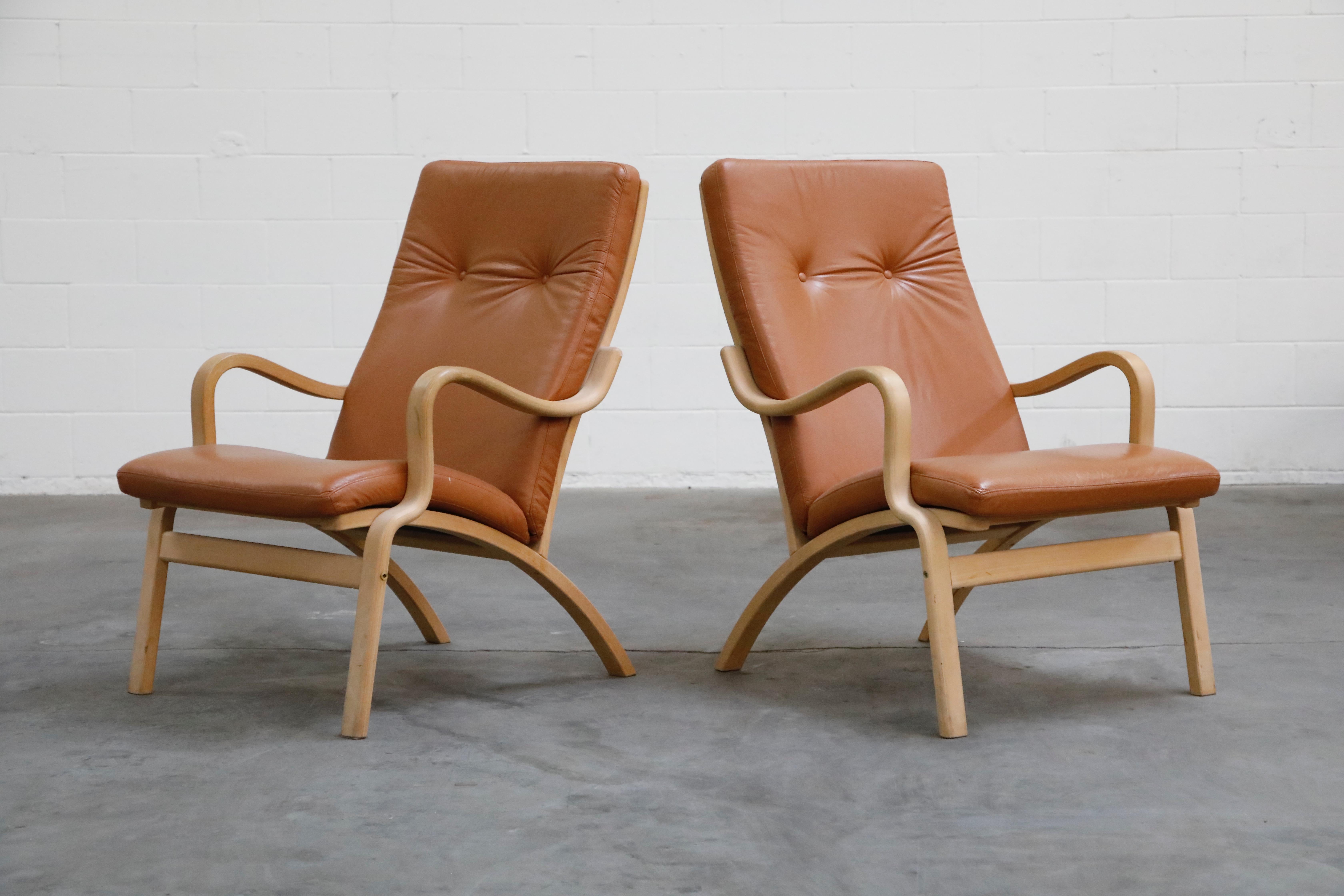 A nice set of two (2) Scandinavian Bentwood leather lounge chairs and one (1) ottoman, priced as a set. Nicely sculpted birch frames with curvaceous arms and brown leather cushions. Well made, great quality materials and craftsmanship, very good