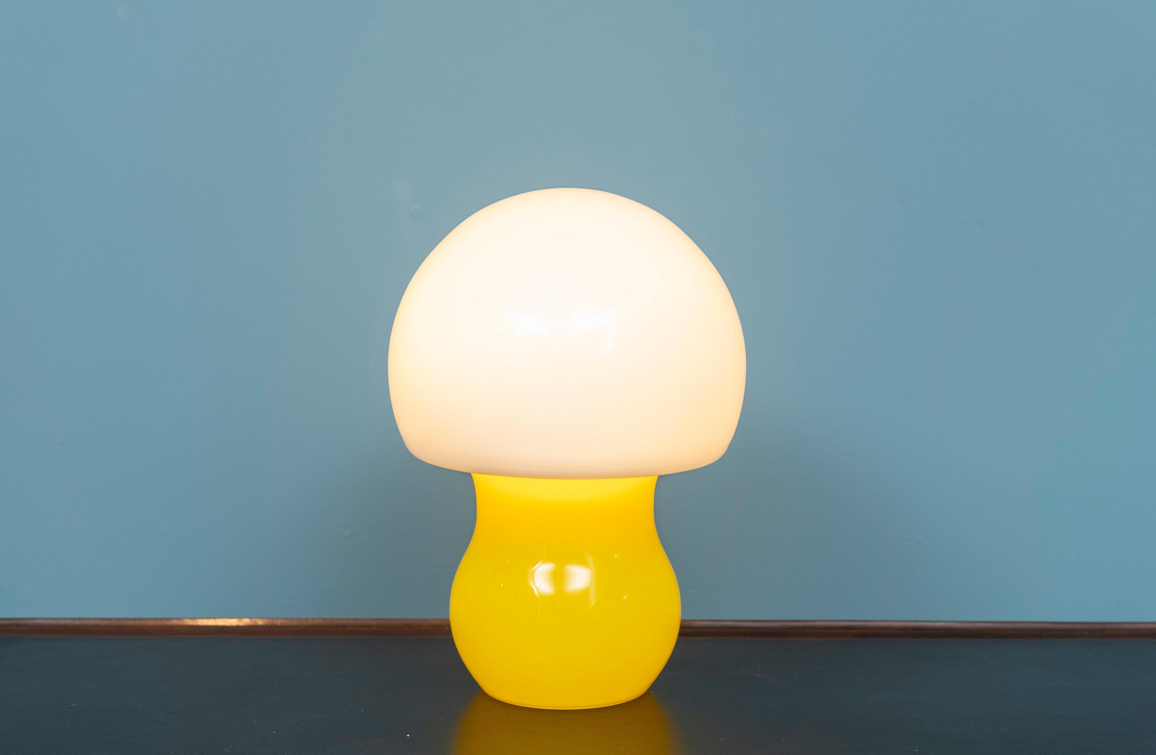 Scandanavian modern glass table lamp attributed to Holmgaard, Denmark. Lovely pop art table lamp in yellow and white cased glass that emits a beautiful happy feeling. In very good original condition.