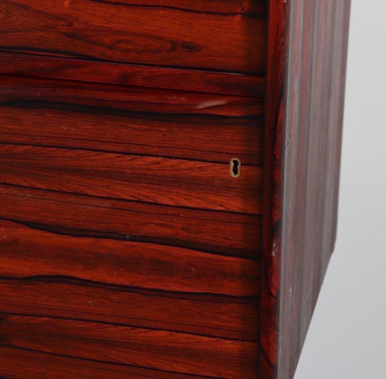 Rare Scandiline floating rosewood cabinet that is made to hang on the wall.
The wall unit features drawers and a filing cabinet. It has great scale but it is the grain of the rosewood that steals the show. The file cabinet section has lock and key.