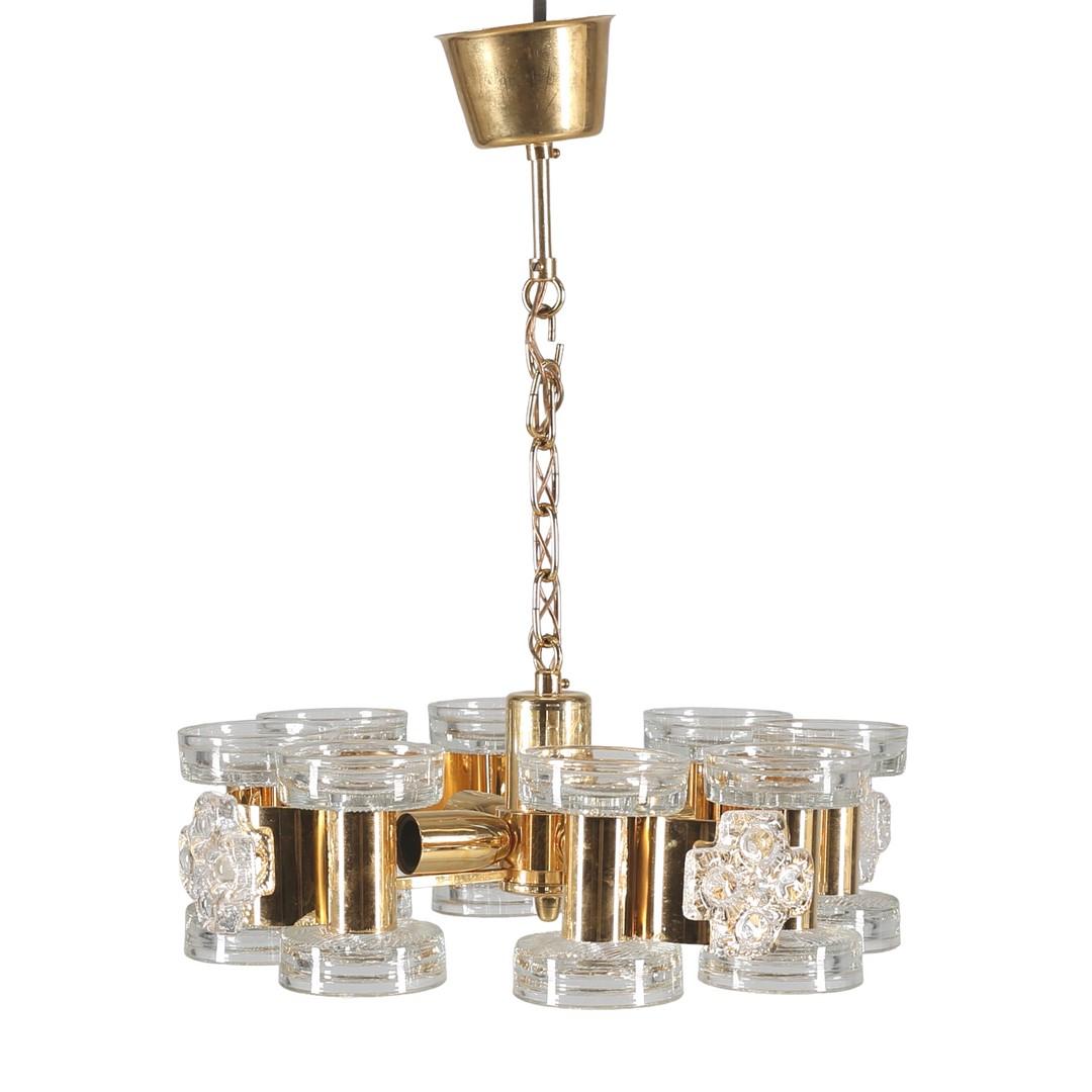 Elevate your space with the mesmerizing Scandinavian Modern ceiling lamp in brass and pressed glass by the celebrated designer Carl Fagerlund. This iconic piece is a true embodiment of timeless design, seamlessly blending form and function to