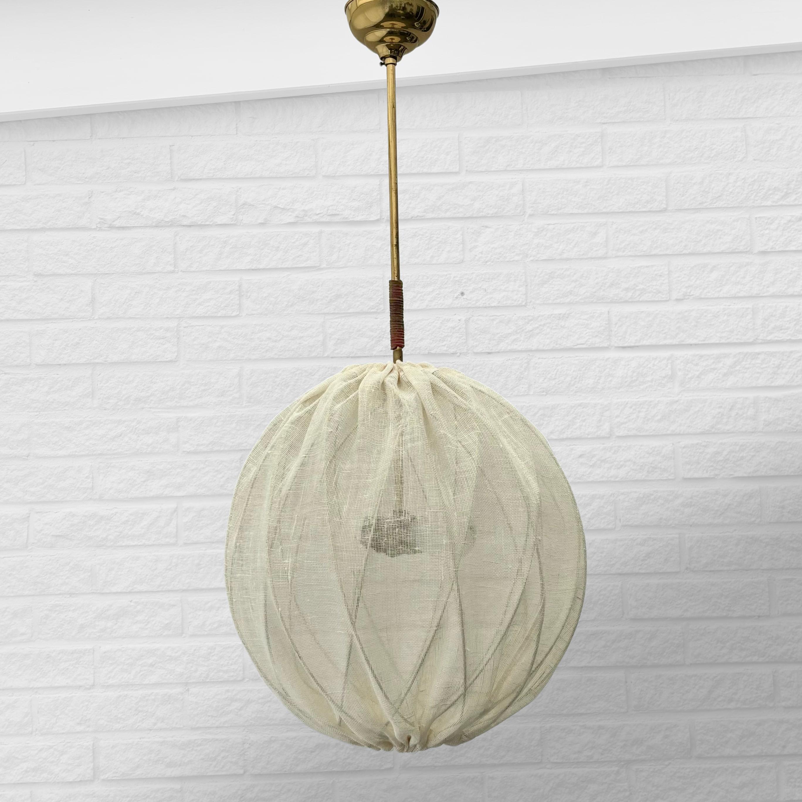 A large globe shaped pendant lamp attributed to the Swedish architect Tore Ahlsén and probably produced for the Swedish consumer’s cooperative KF in the early 1950s. It features a round shade with a geometrical shaped metal skeleton covered in a